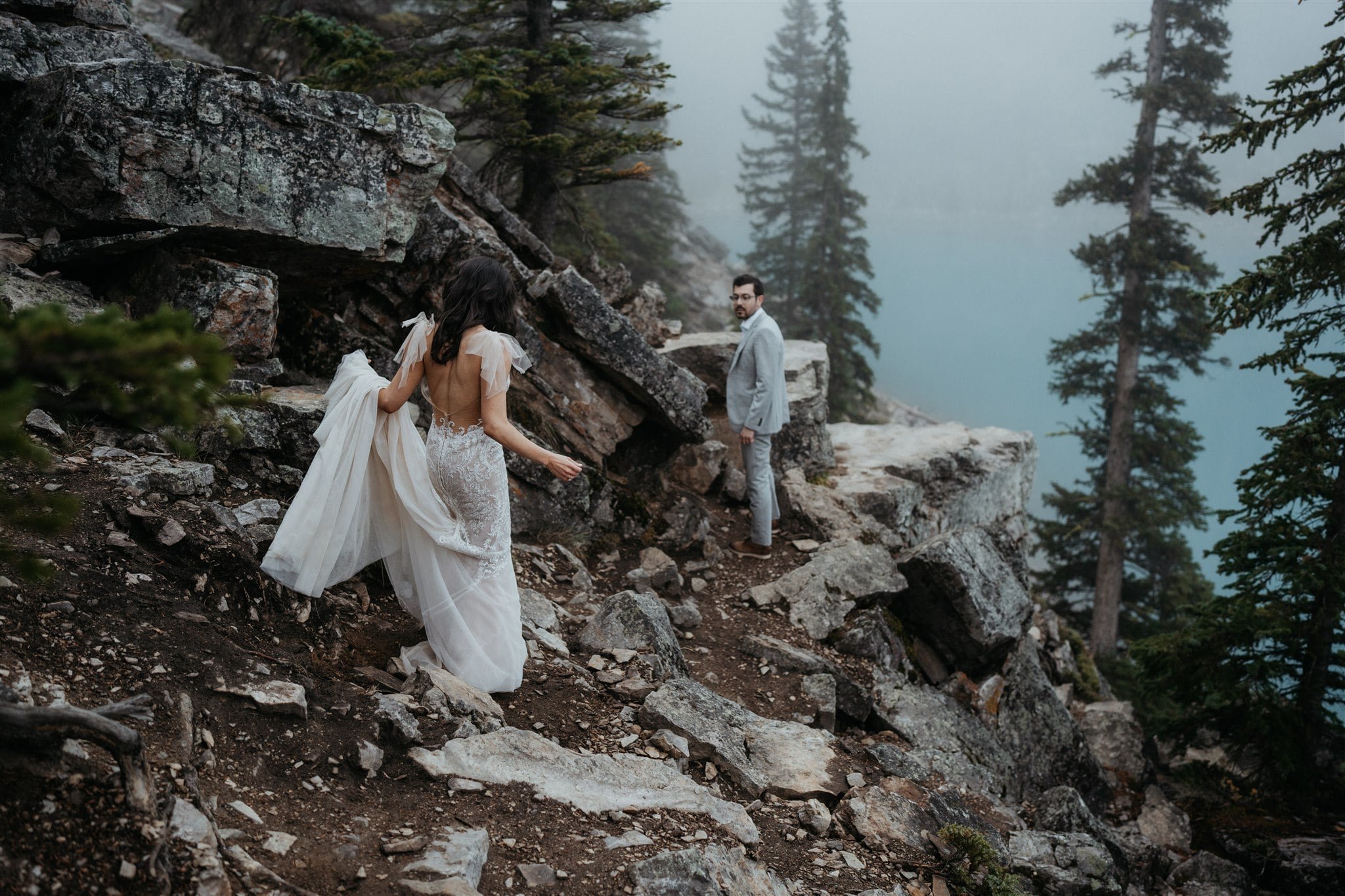 Bride and groom hiking a mountain trail during their adventure elopement in Banff