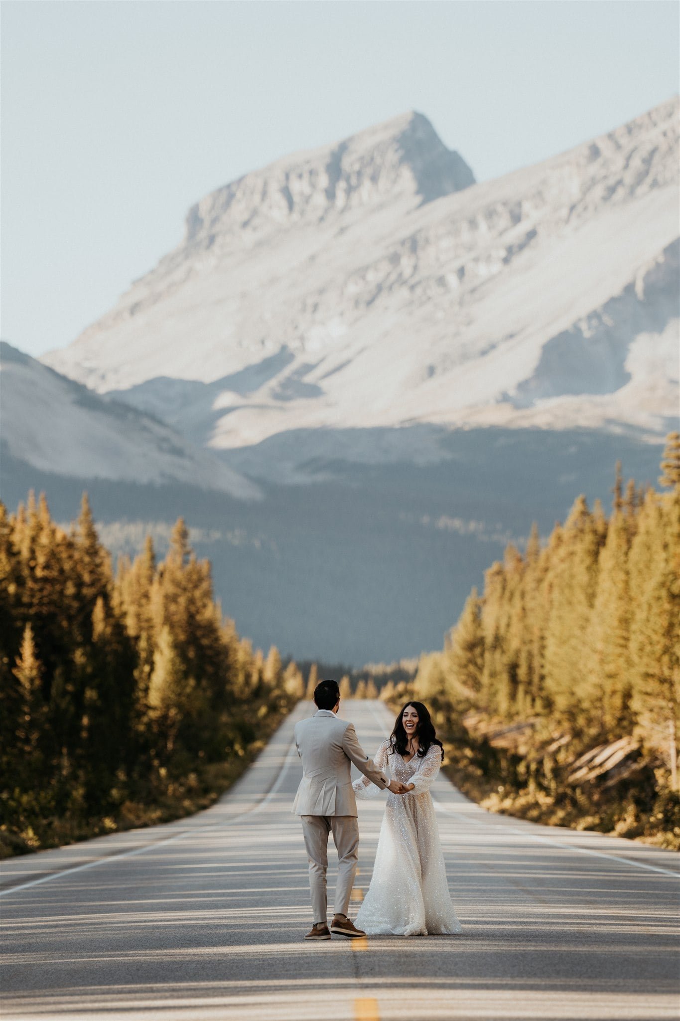 Bride and groom running down a street during their Banff elopement adventure session