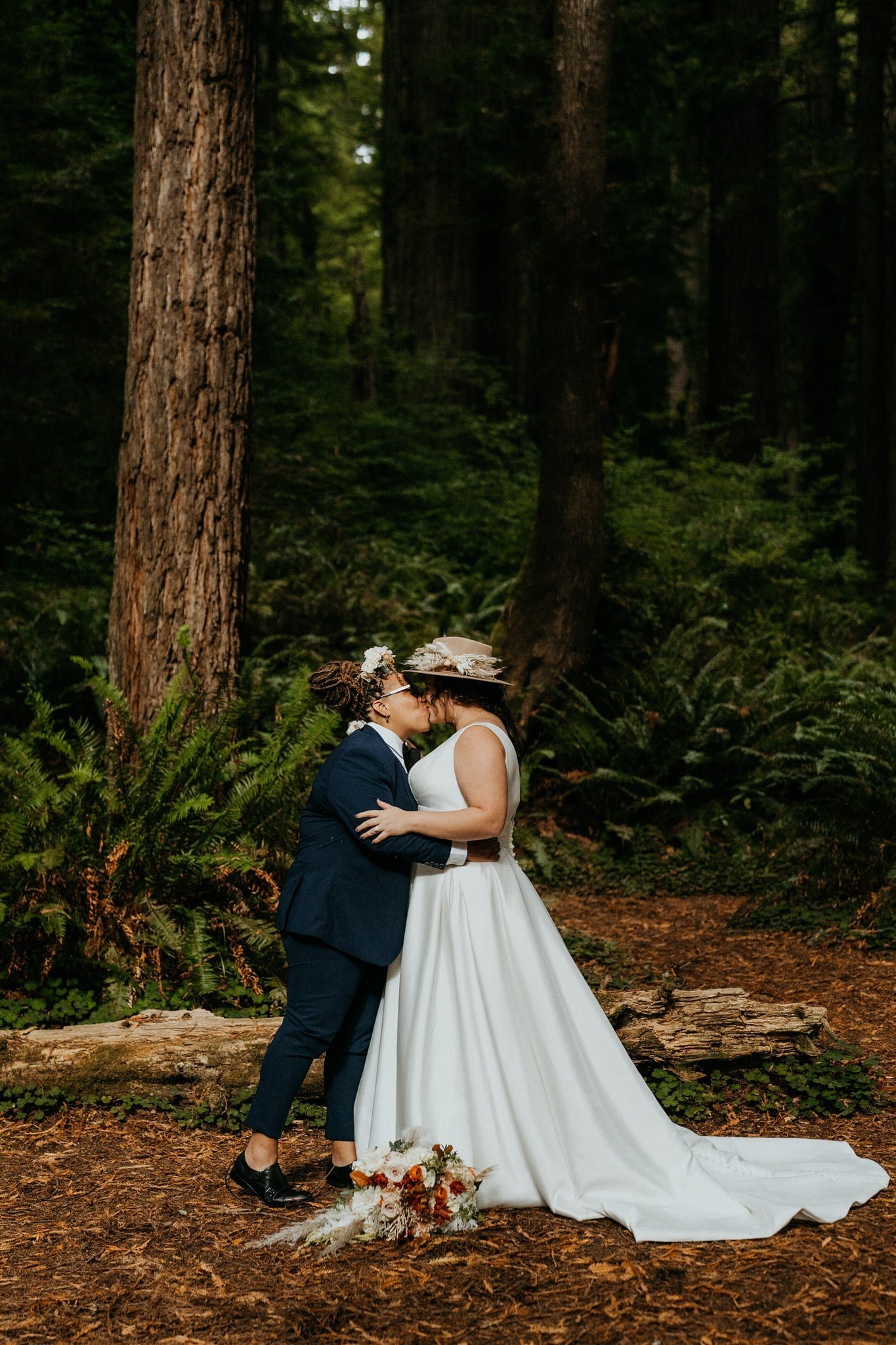 Brides kiss during forest elopement ceremony in Oregon