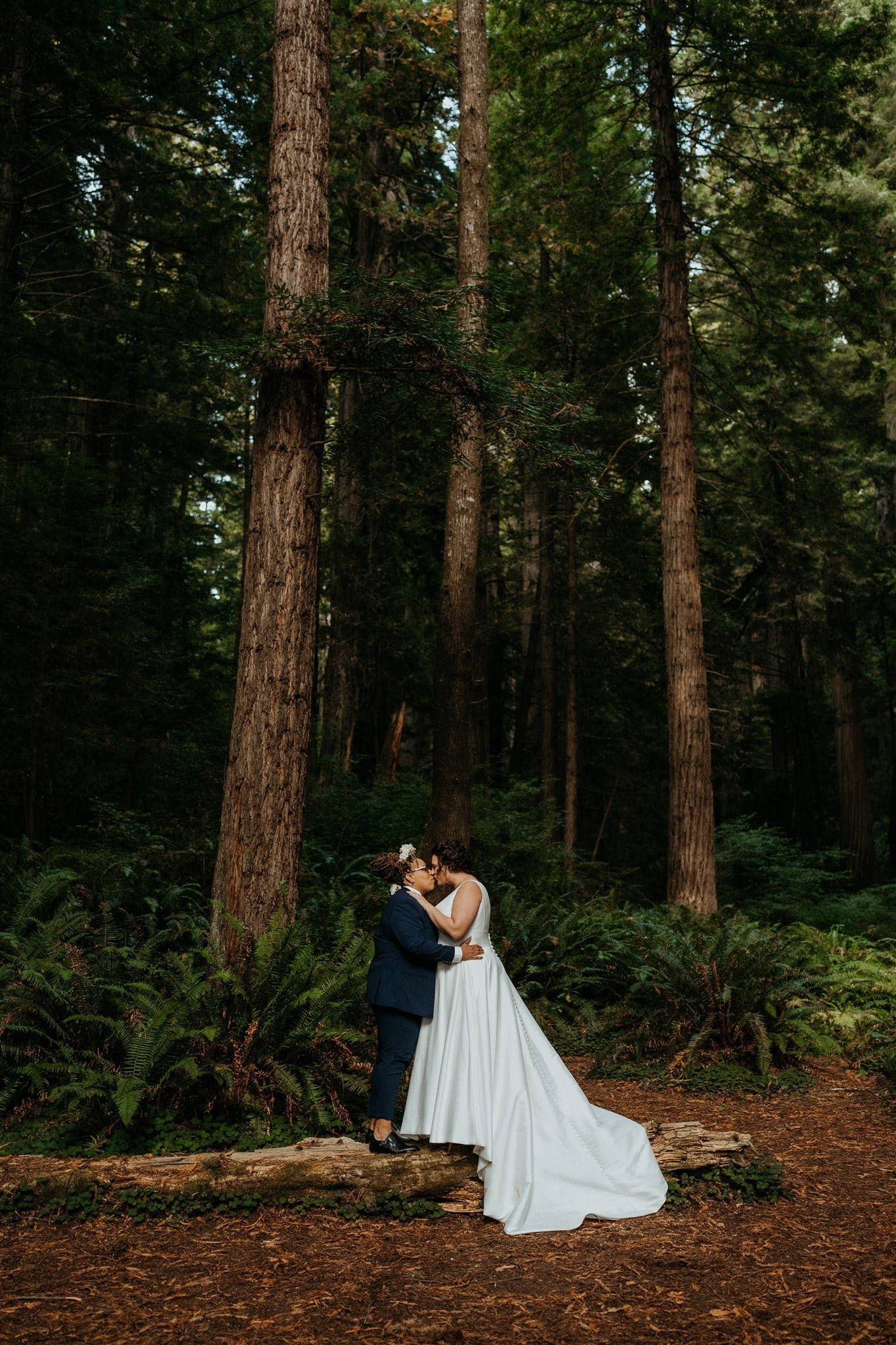 Brides kiss during forest elopement portraits in Oregon