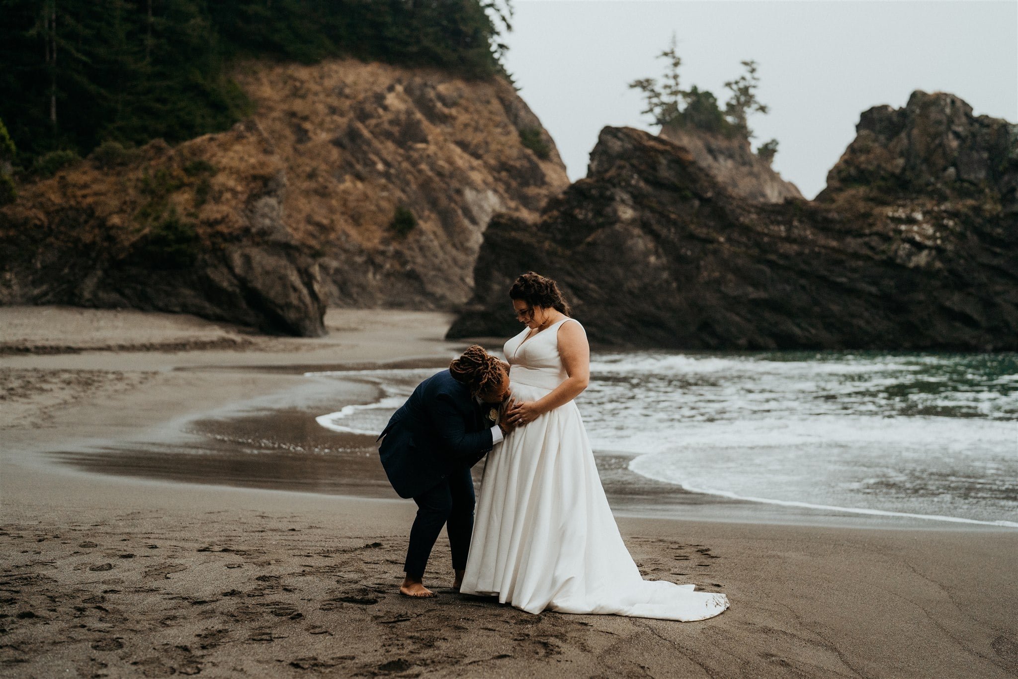 Bride kisses her wife's belly at Southern Oregon Coast elopement