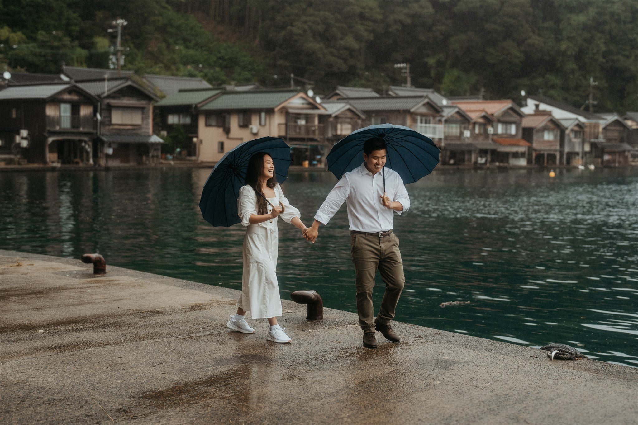 Bride and groom holding hands walking along the boardwalk in Kyoto, Japan