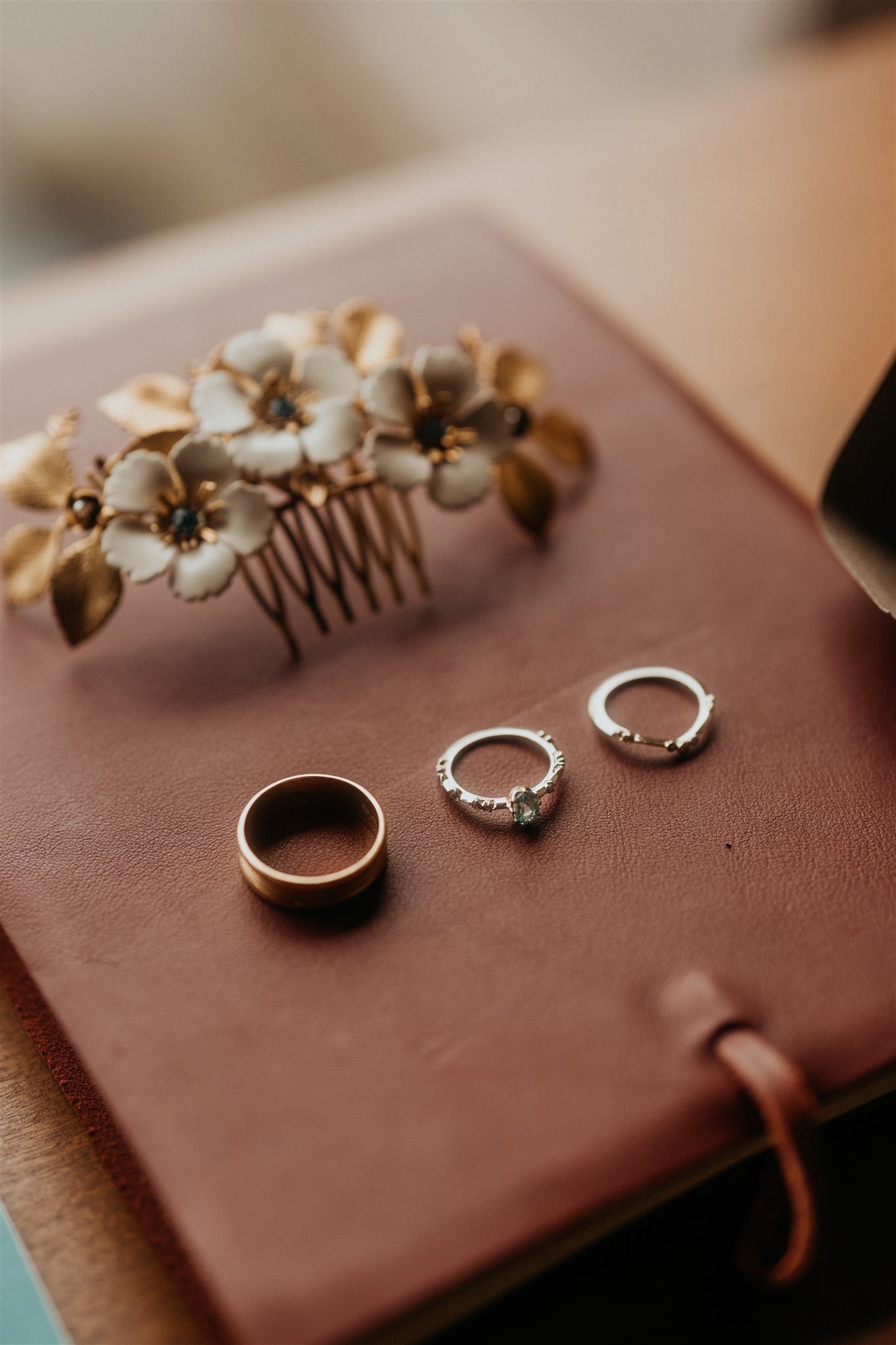 elopement rings and floral hair piece sitting on top of leather vow book