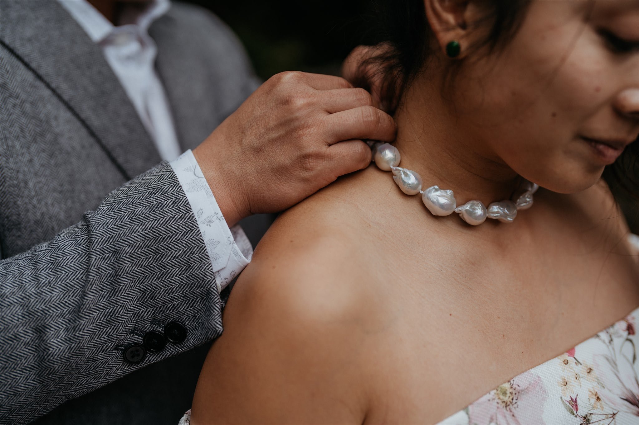 Groom putting pearl necklace around bride's neck during Japan elopement first look