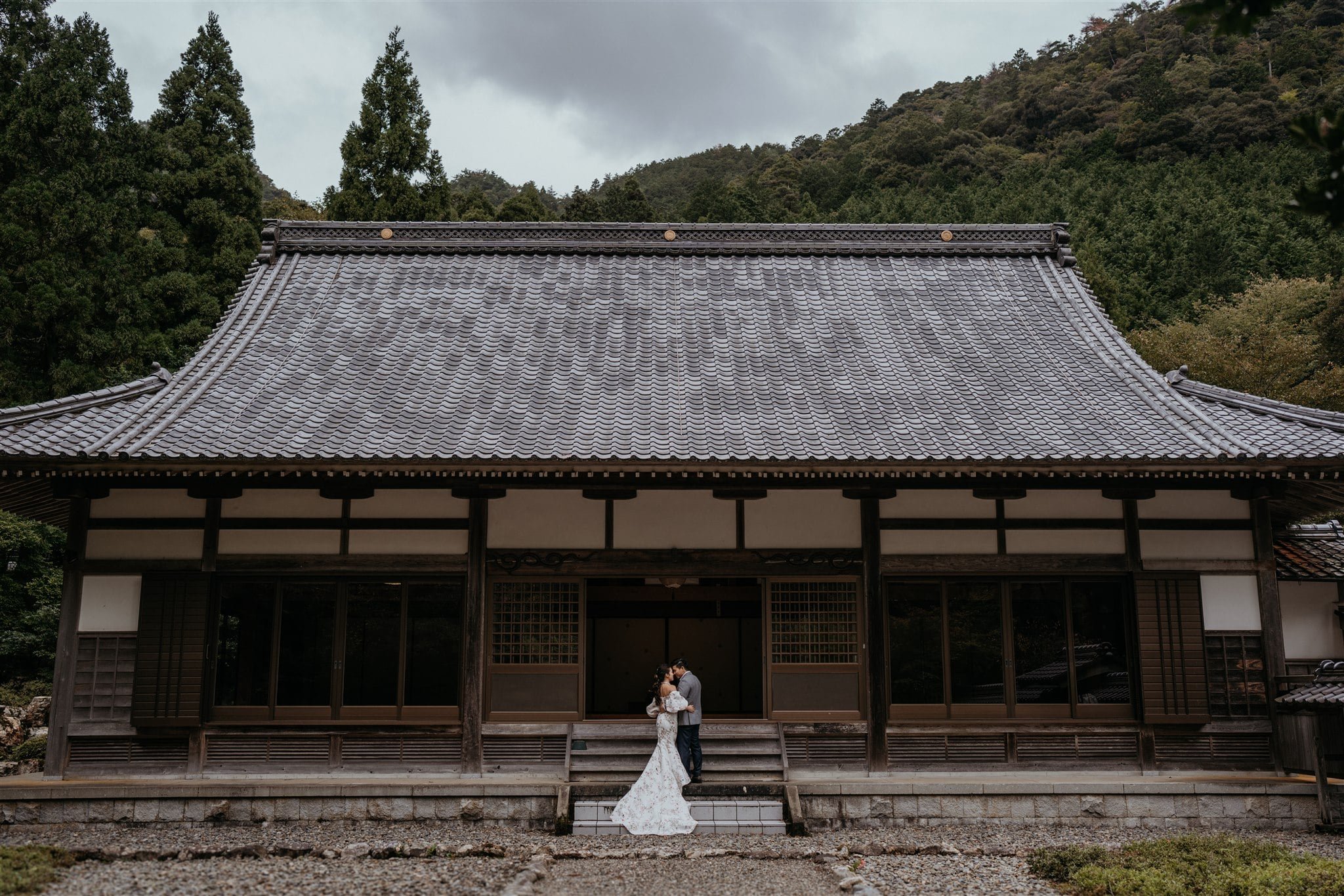 Bride and groom kiss on the steps of a hut during Japan elopement