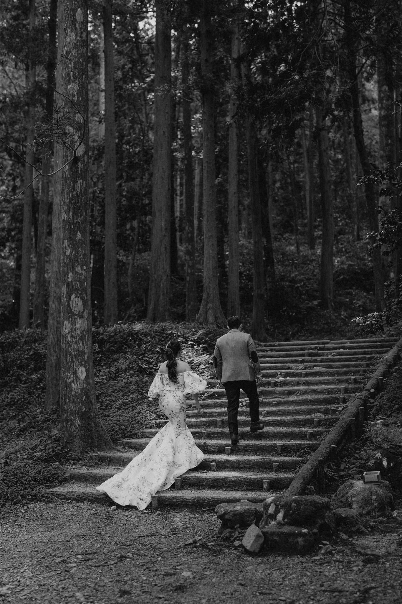 Bride and groom walking up steps in the forest during their Japan elopement portraits