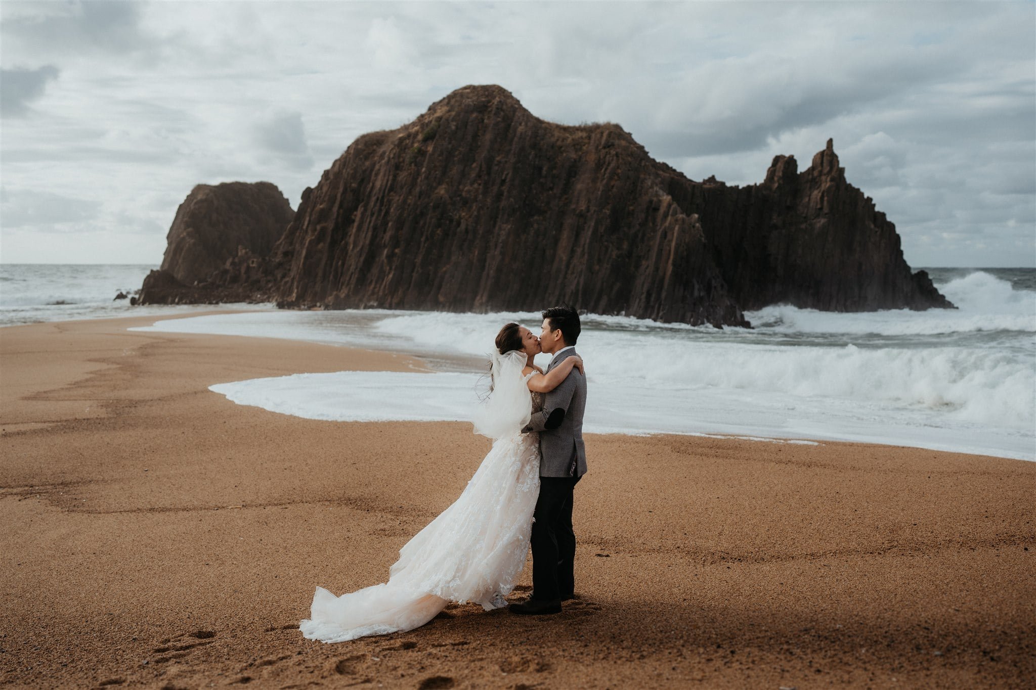 Bride and groom kiss during beach elopement ceremony in Kyoto