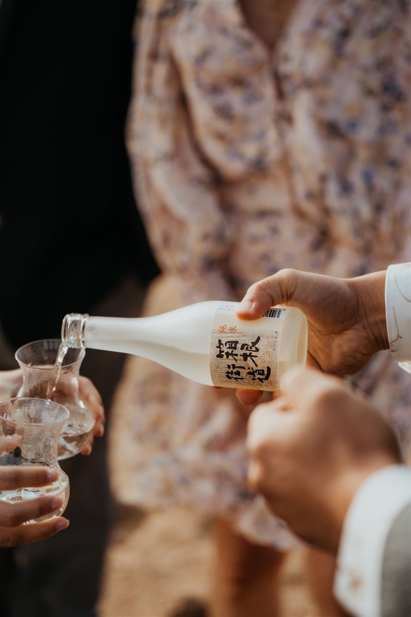 Groom pouring sake after beach elopement ceremony