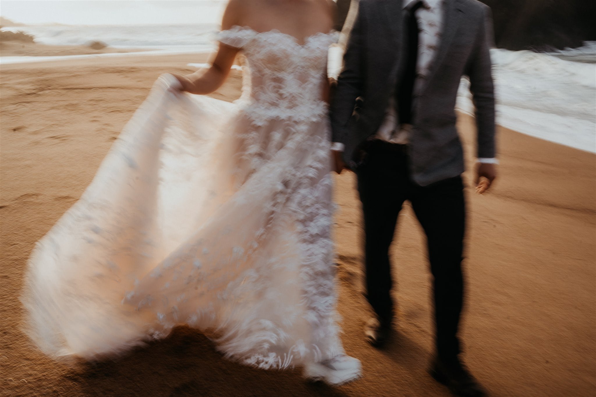 Bride and groom run across the beach during their elopement in Japan