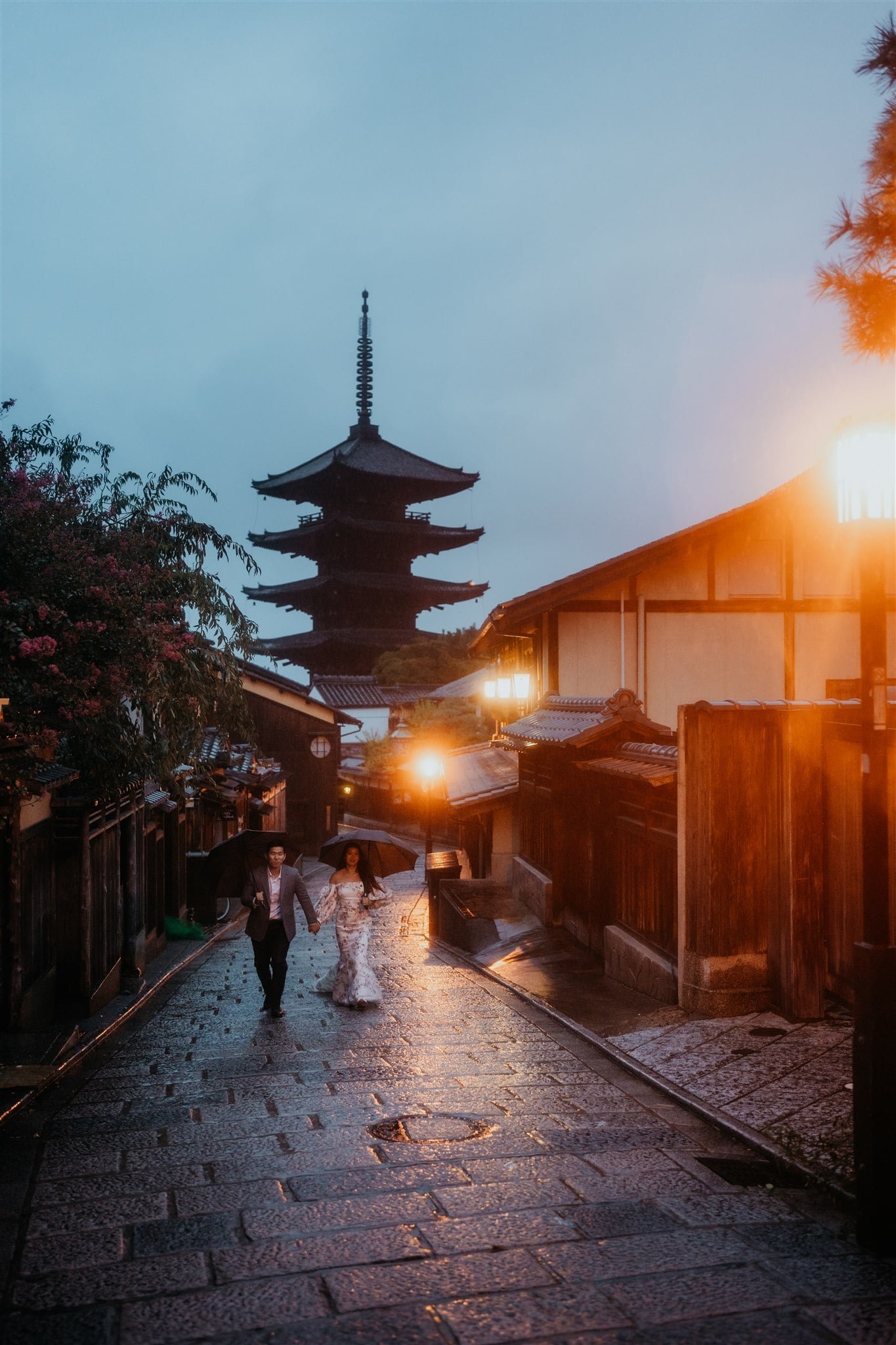 Bride and groom walk down the streets in Kyoto during blue hour