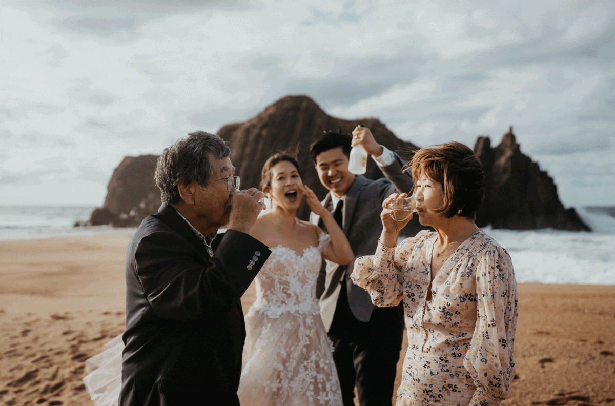Bride and groom's parens drink sake on the beach after outdoor elopement ceremony