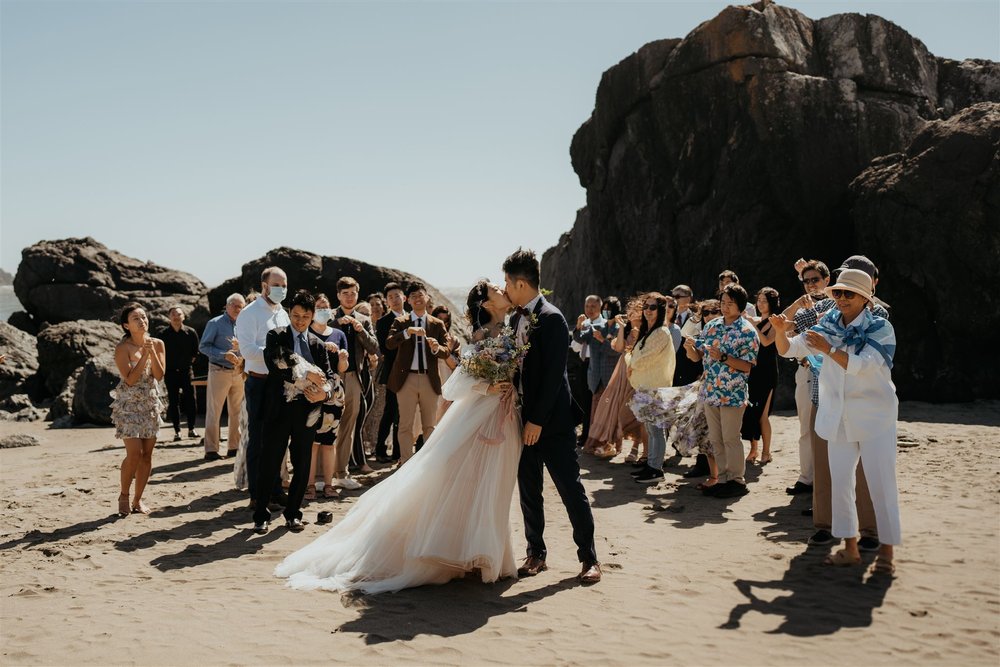 Bride and groom kiss during elopement on the beach in Oregon