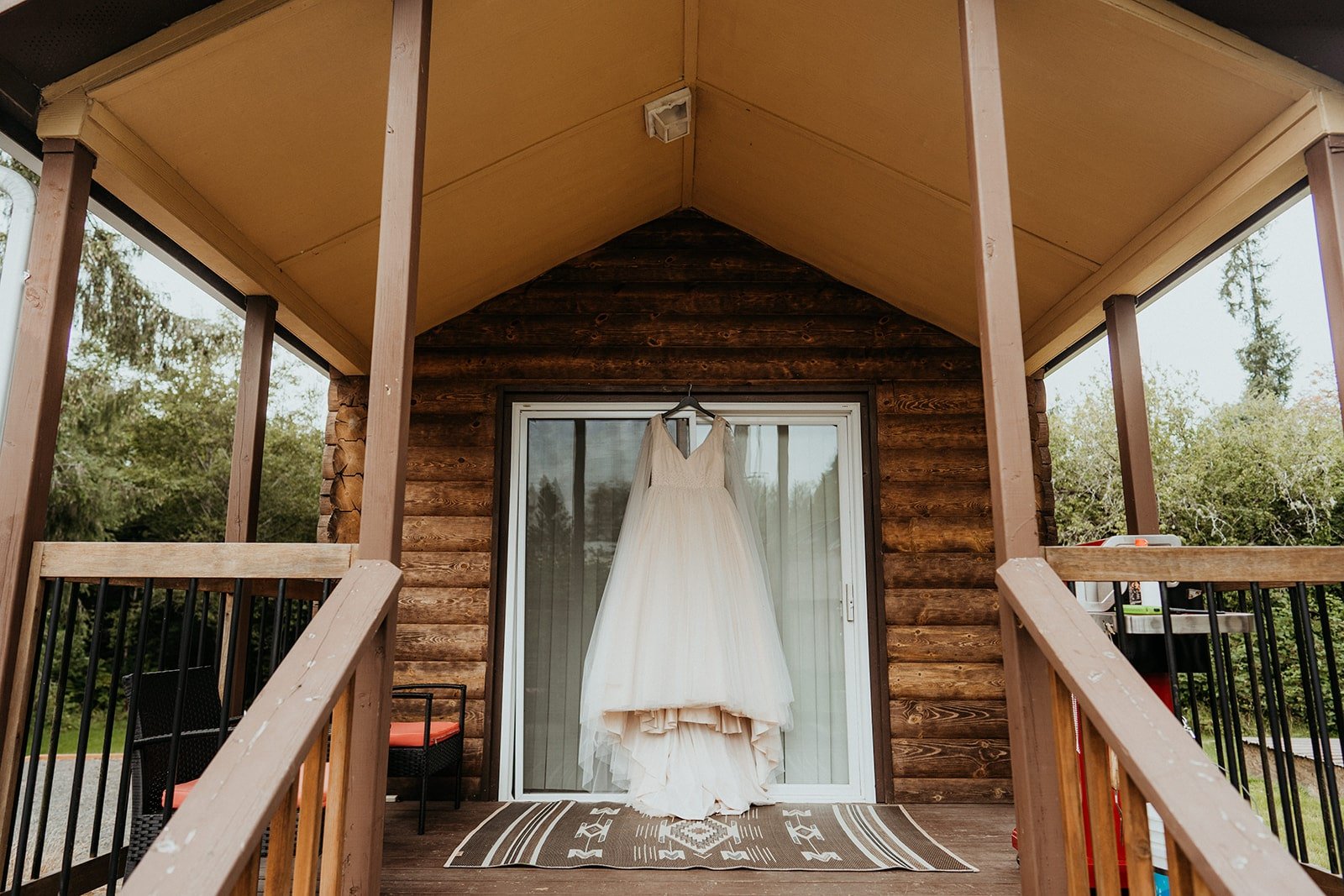 White tulle wedding dress hanging from the door of cabin