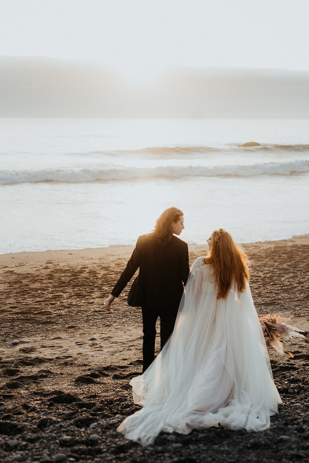 Bride and groom walk across the sand during their Rialto Beach elopement