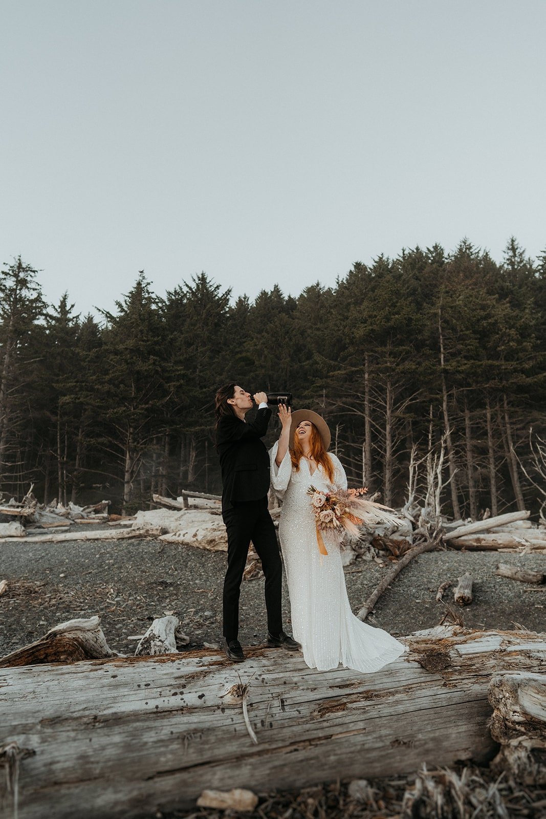 Bride and groom drink champagne during their Rialto Beach elopement
