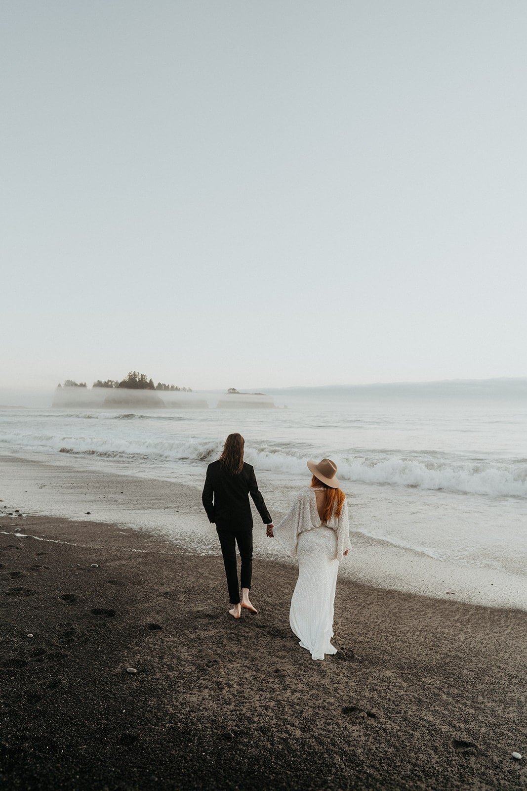 Bride and groom run towards the water during their Rialto Beach elopement