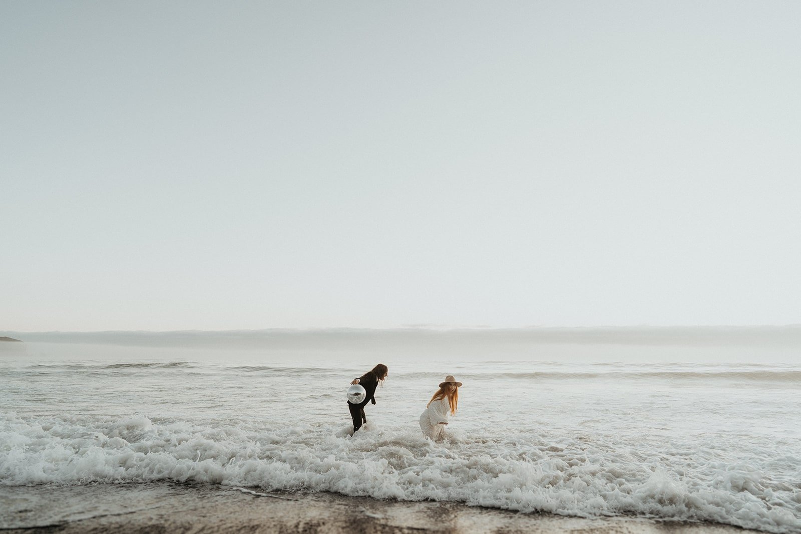 Bride and groom run through the water during their elopement at Rialto Beach