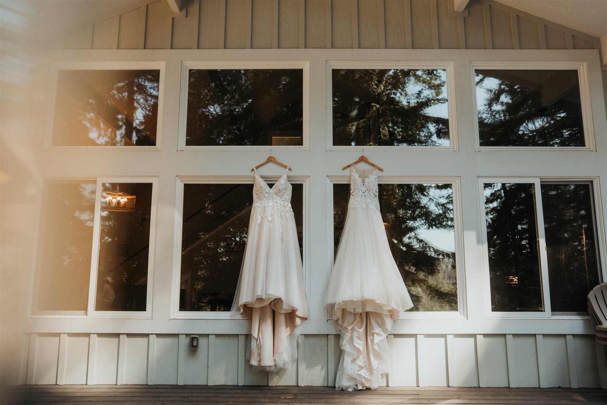 Two white wedding dresses hanging from a cabin on the Oregon Coast