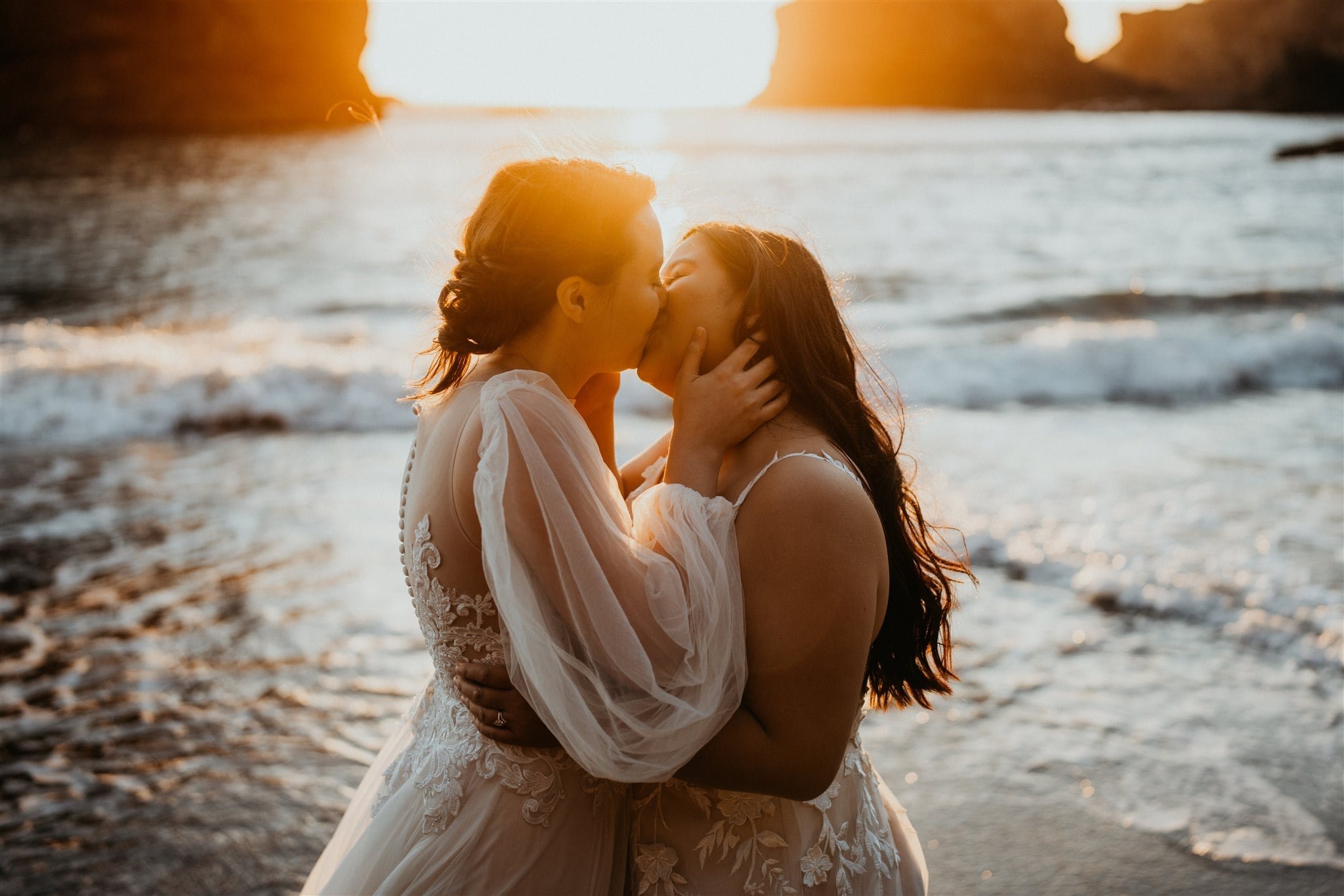 Brides kissing in the ocean during their sunset photos at Secret Beach, Oregon elopement