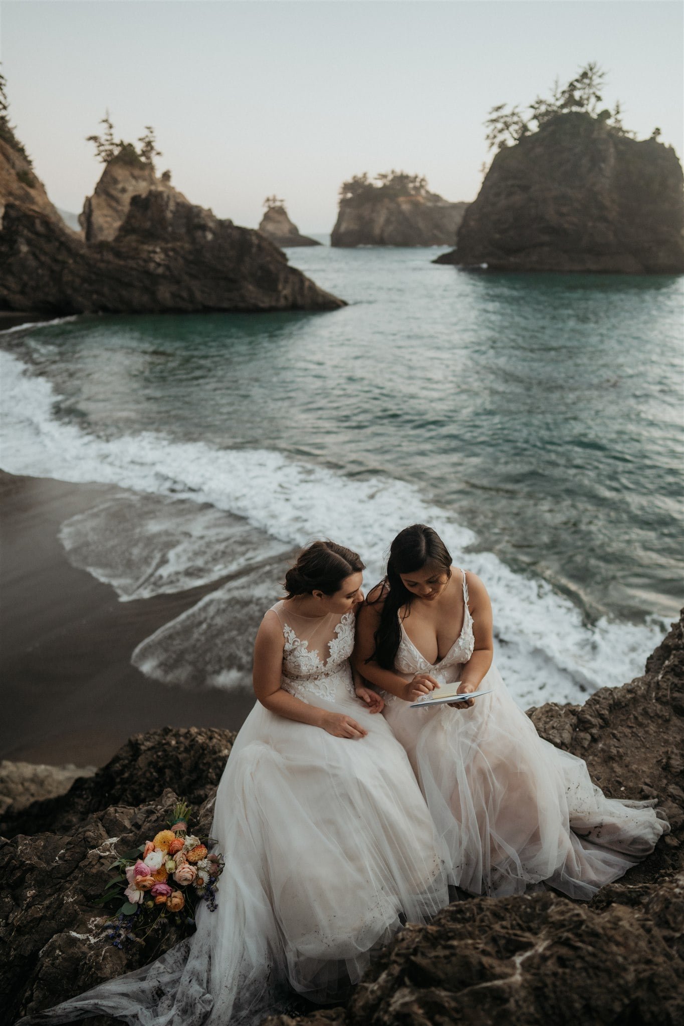Brides reading letters from loved ones during their elopement at Secret Beach