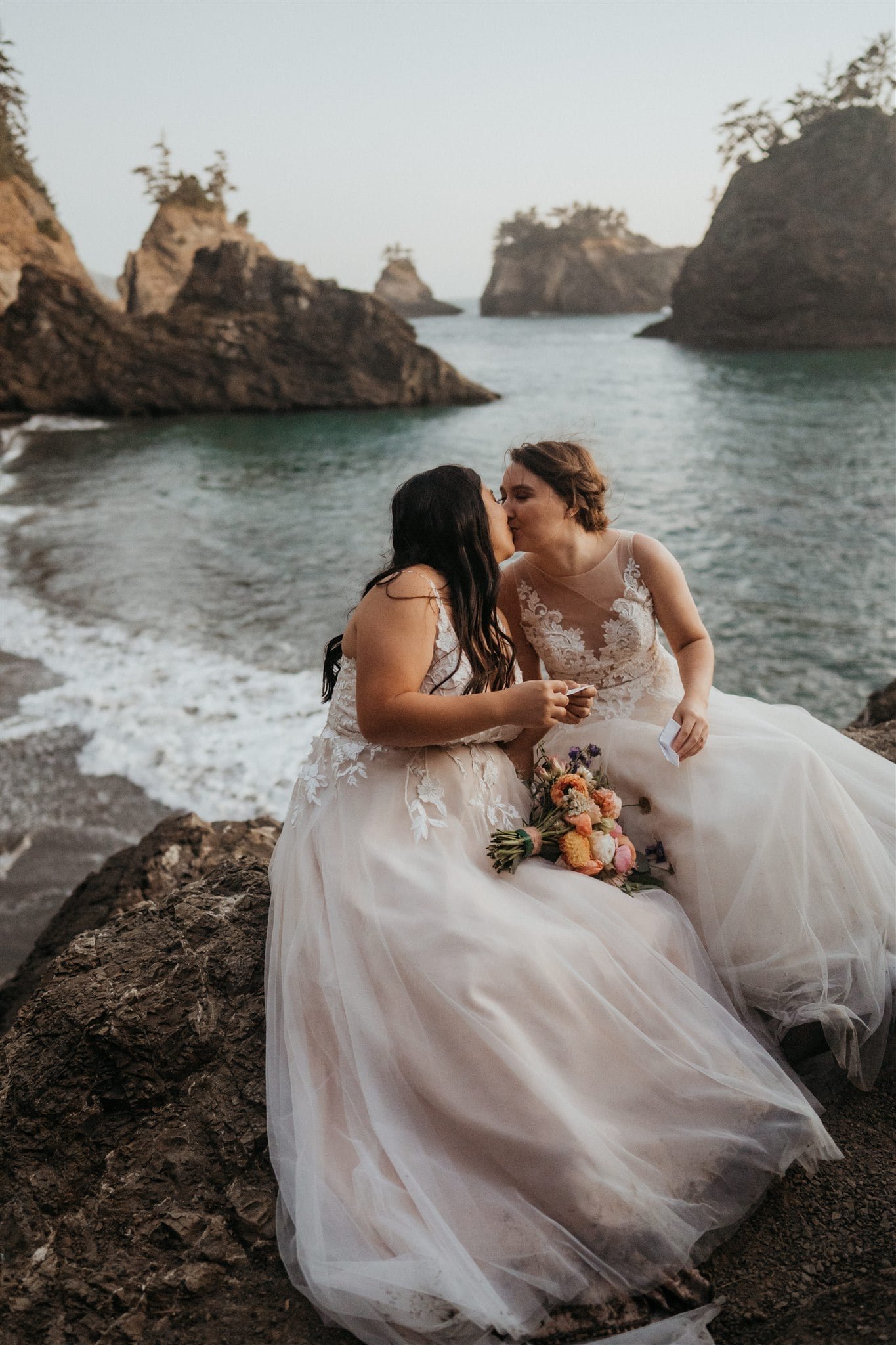 Brides reading letters from loved ones during their elopement at Secret Beach