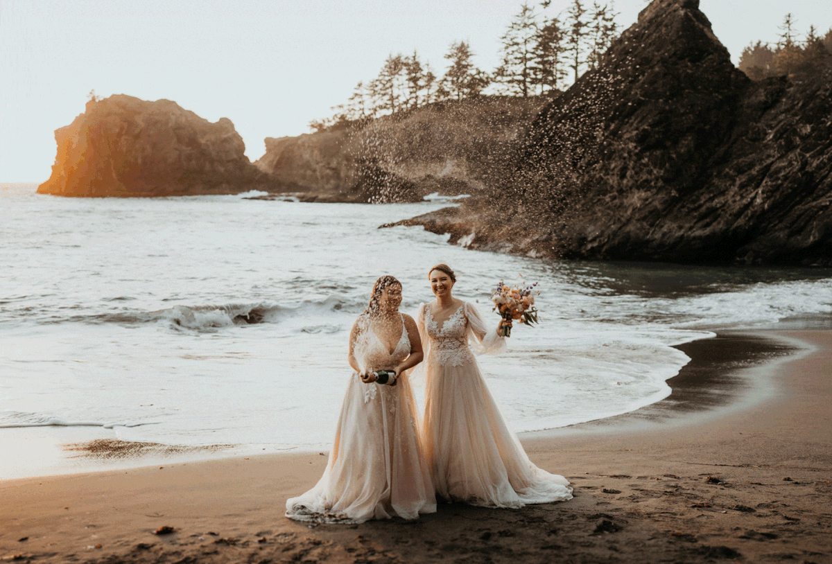 Brides spraying champagne during their elopement at Secret Beach