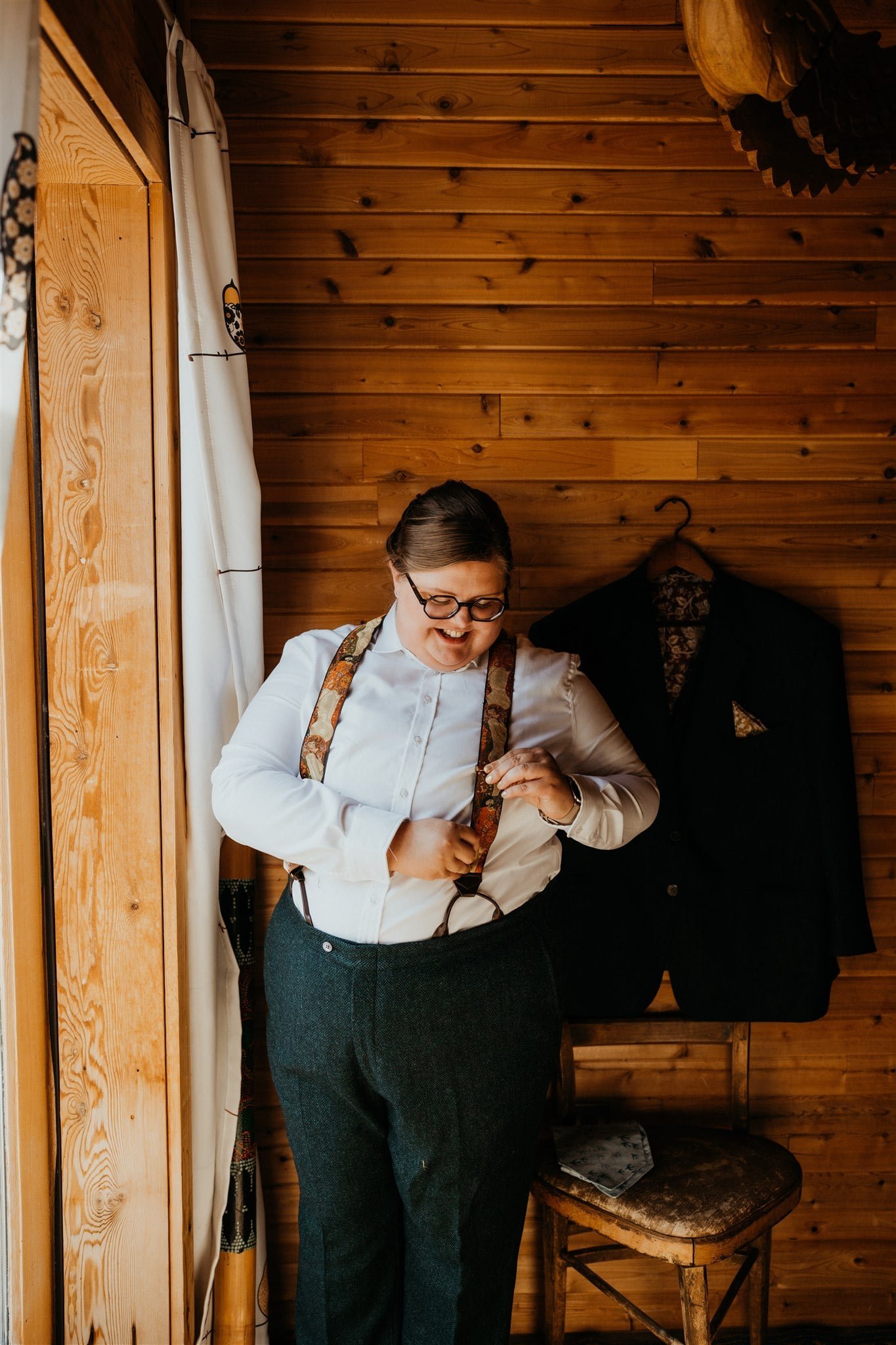 Bride adjusting suspenders while getting ready for elopement at Olympic National Park