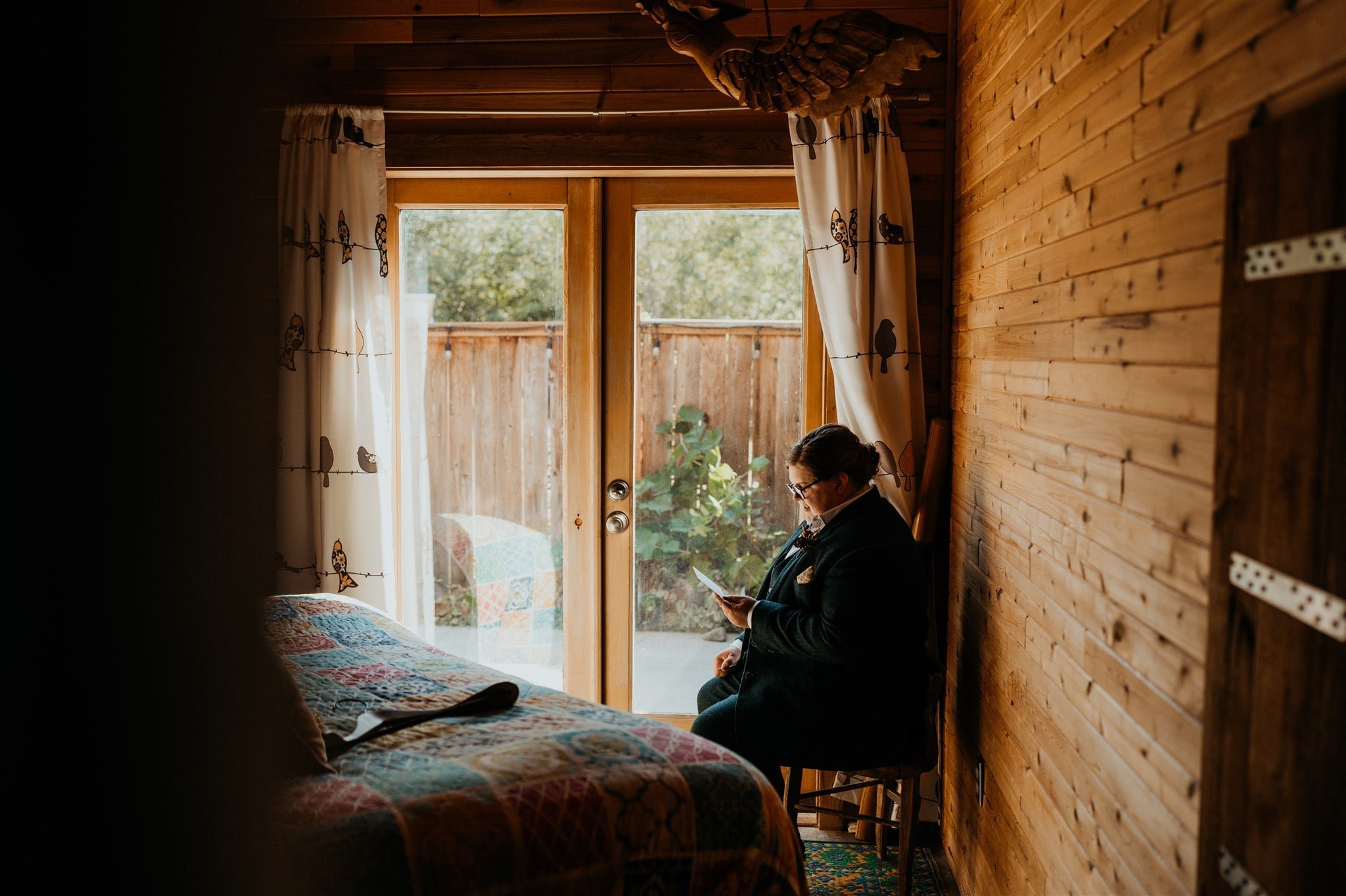 Bride sitting in cabin in Olympic National Park reading handwritten card on her elopement morning