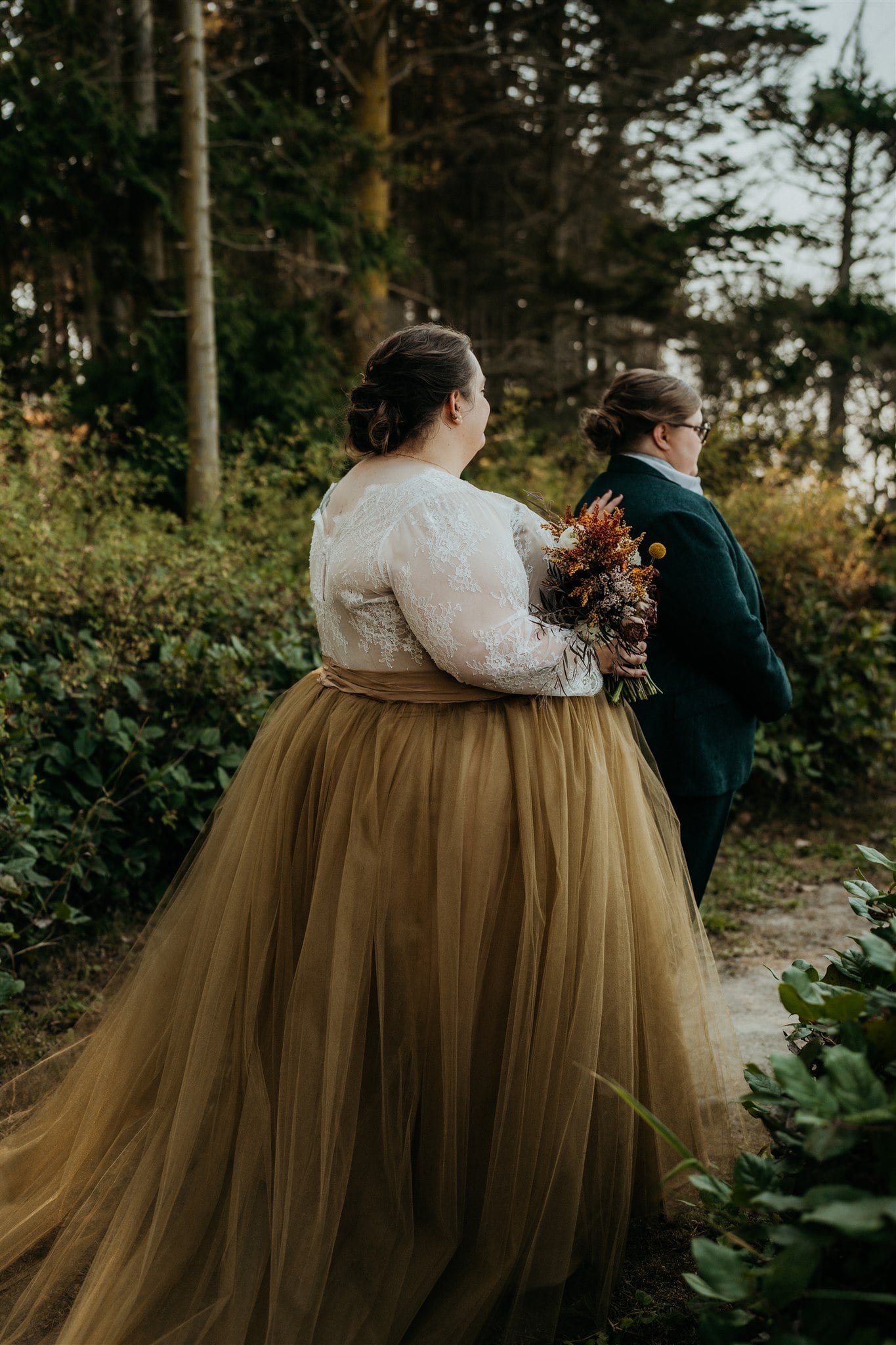 Bride taps her partner on the shoulder for a wedding first look in Olympic National Park