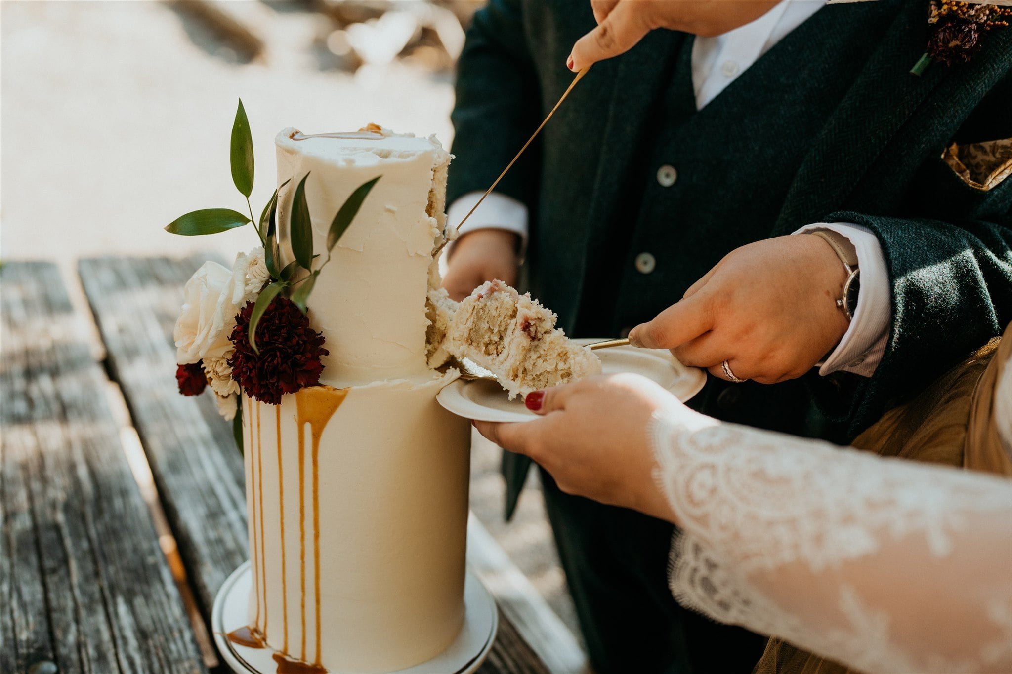 Brides cut into white two tier wedding cake at Lake Crescent elopement