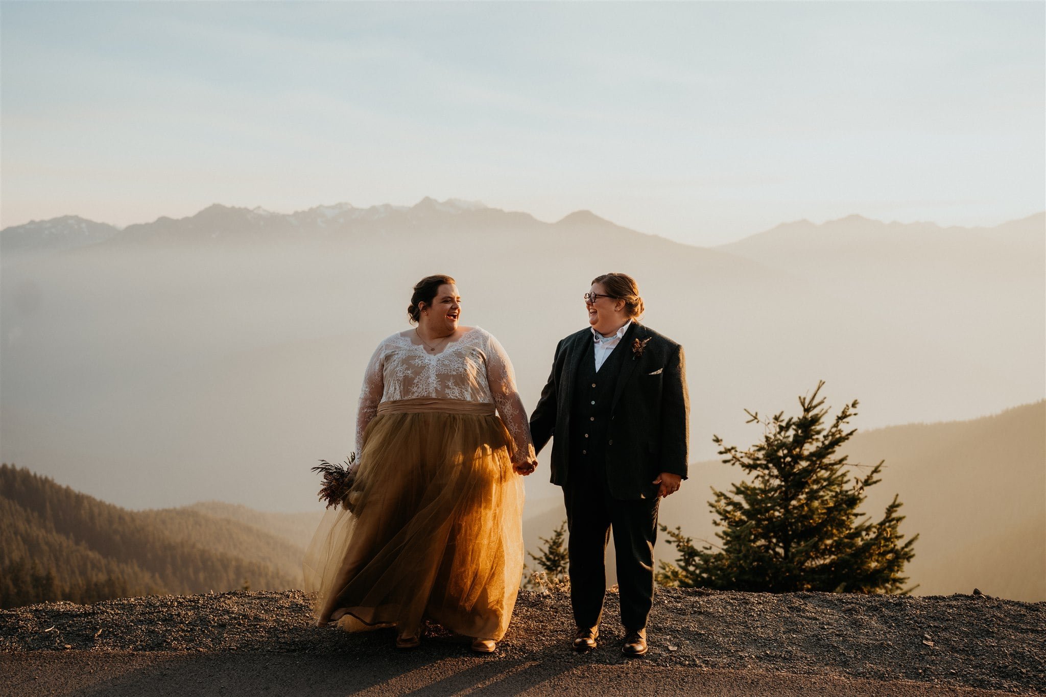 Two brides hold hands during sunset portraits in Olympic National Park