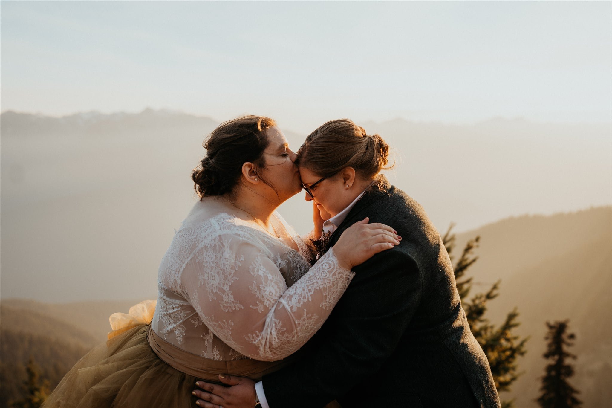 Bride kisses her partner on the forehead during Olympic National Park elopement portraits