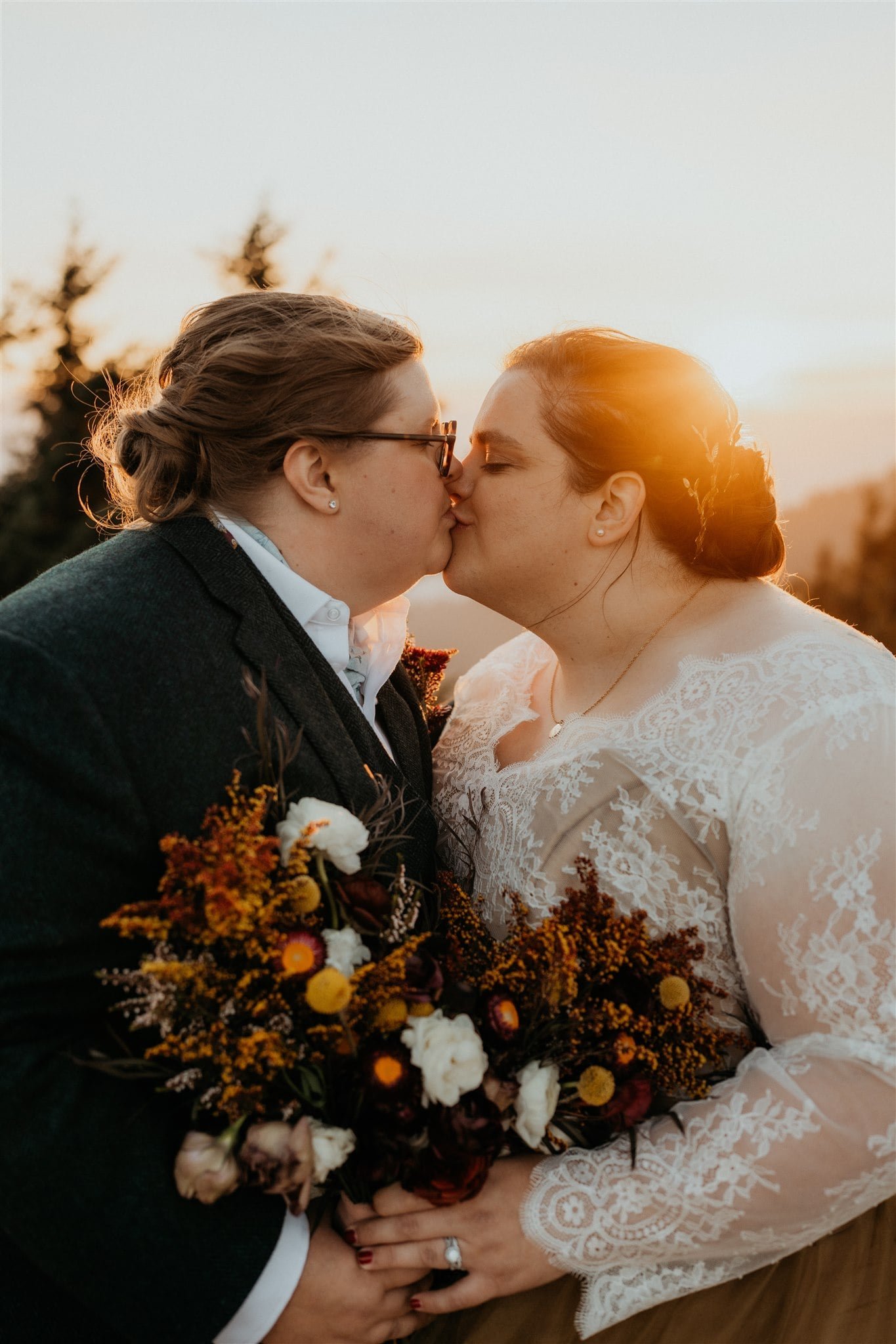 Brides kiss during sunset portraits at Olympic National Park