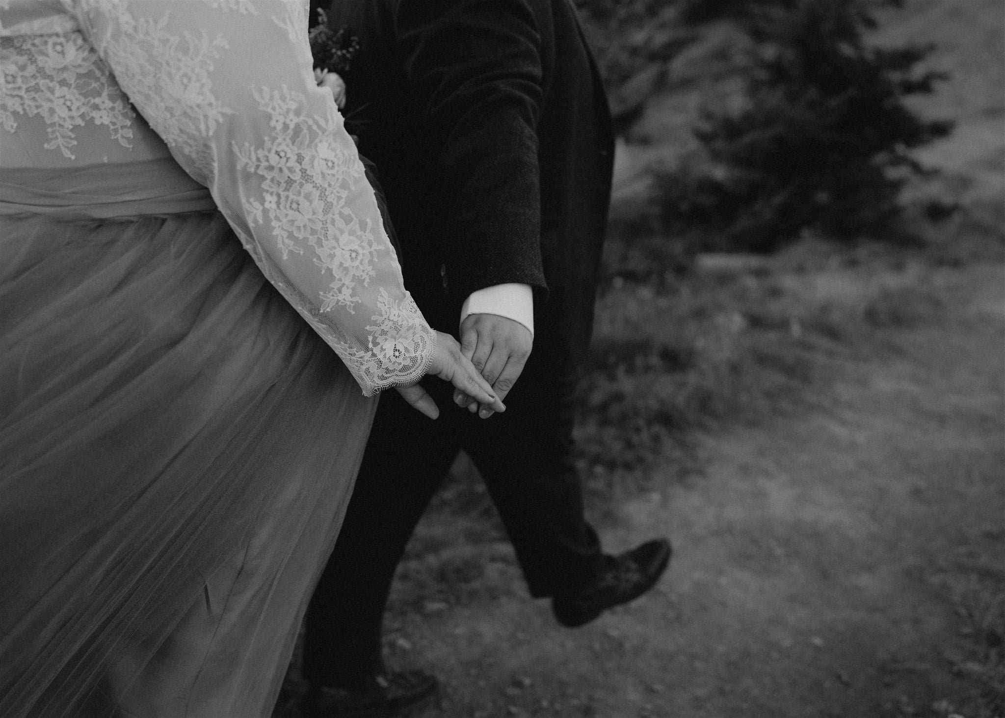 Brides hold hands while walking down a trail at their Olympic National Park elopement