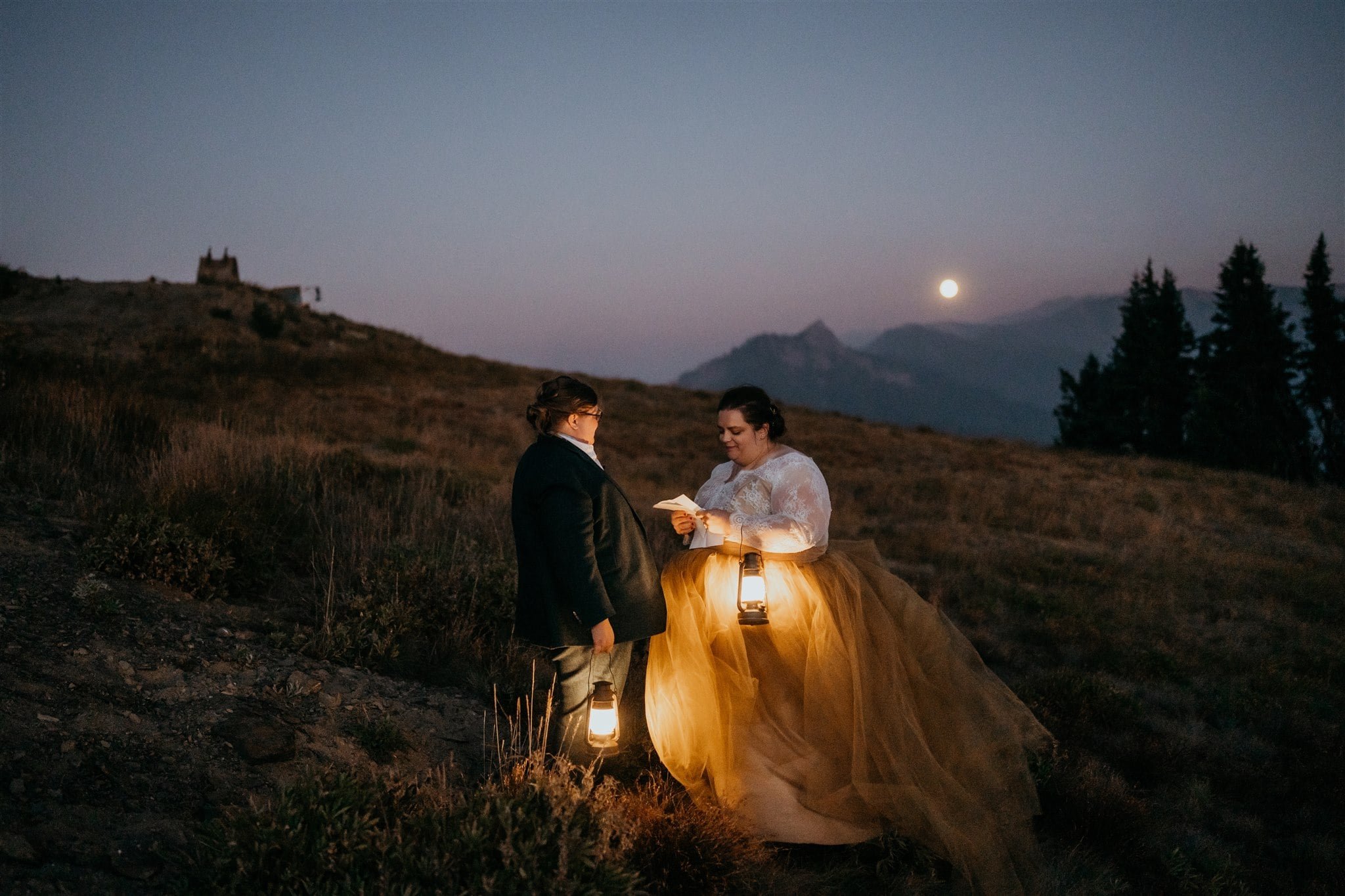 Brides hold lanterns and read private vows to each other at blue hour