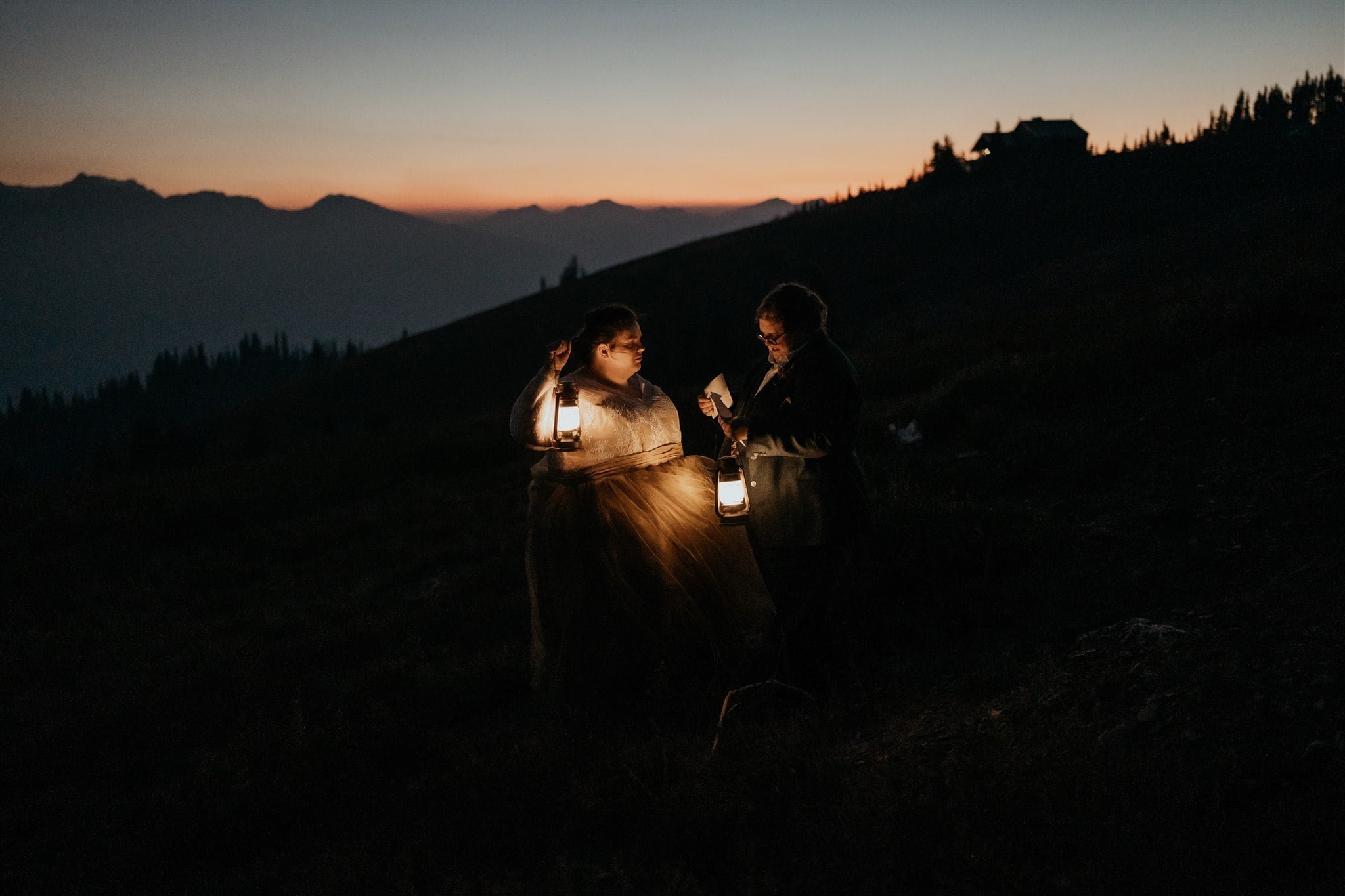 Brides reading private vows by lantern light at Olympic National Park elopement