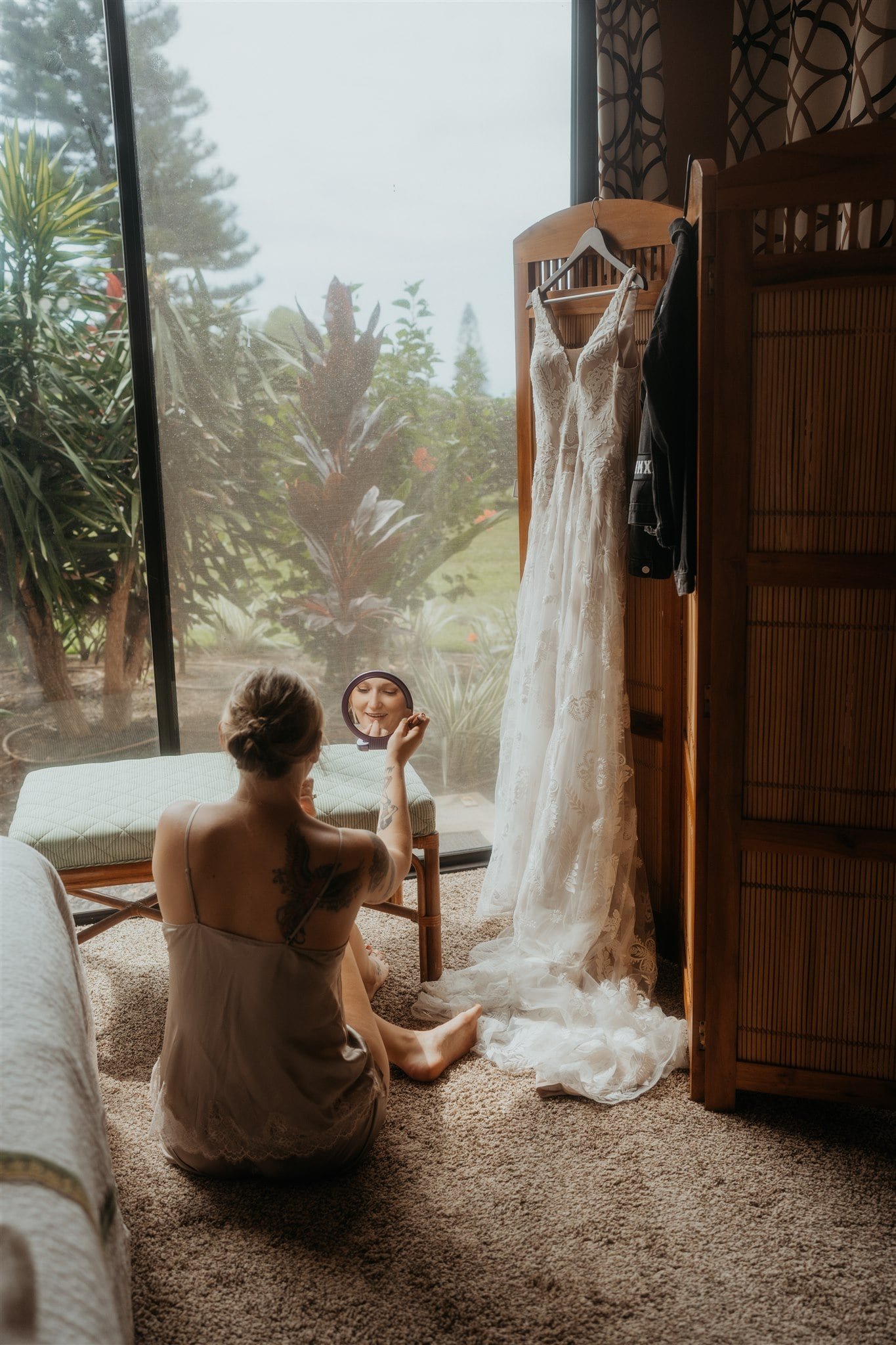 Bride sitting on the floor getting ready for her Big Island elopement