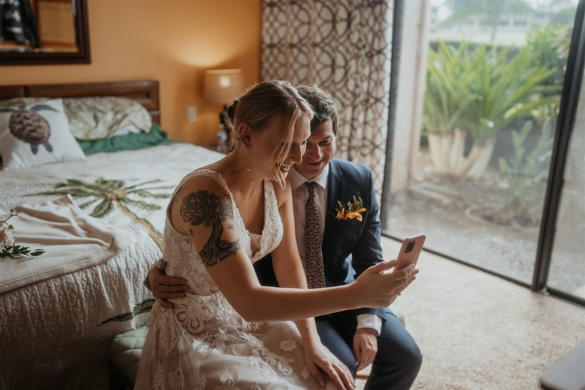 Bride and groom FaceTime family and friends before their Big Island elopement ceremony