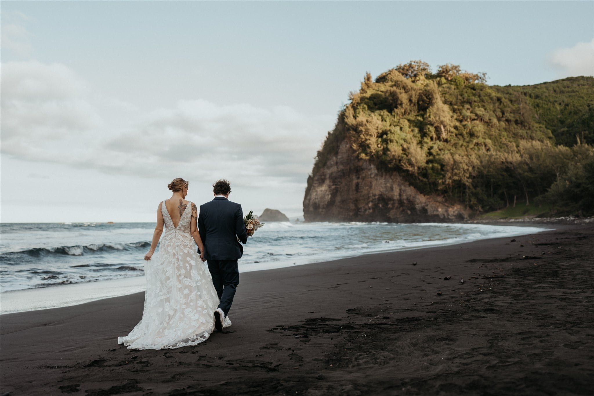 Bride and groom walk across the beach during their Big Island elopement photos