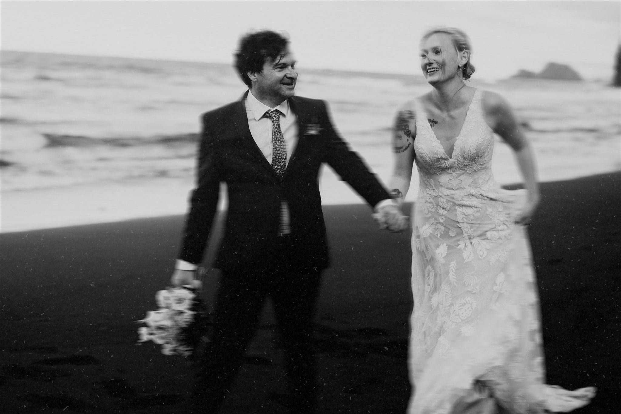 Bride and groom hold hands while running across the beach for their elopement in Hawaii