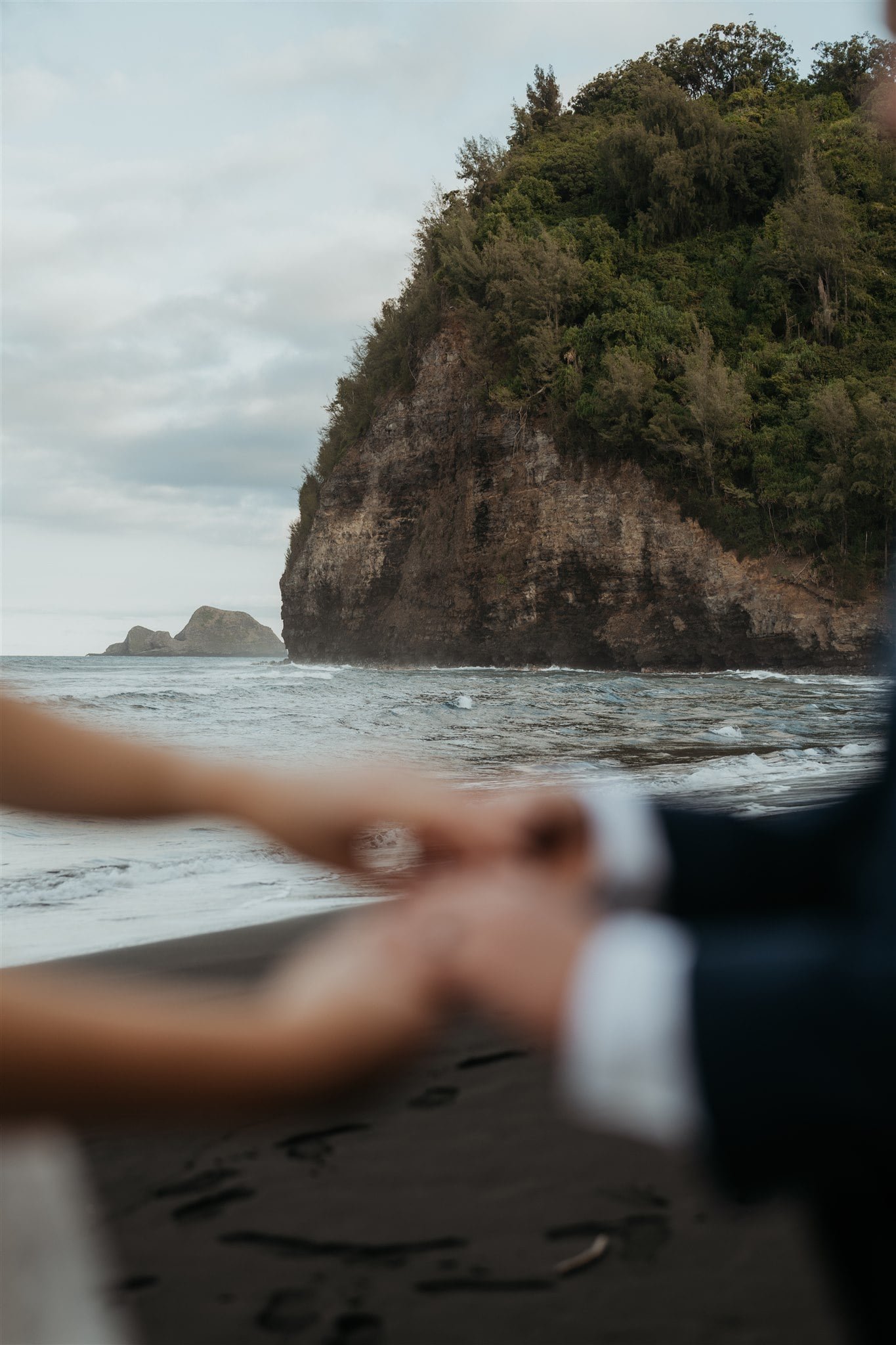Bride and groom hold hands on the beach at their elopement on the Big Island