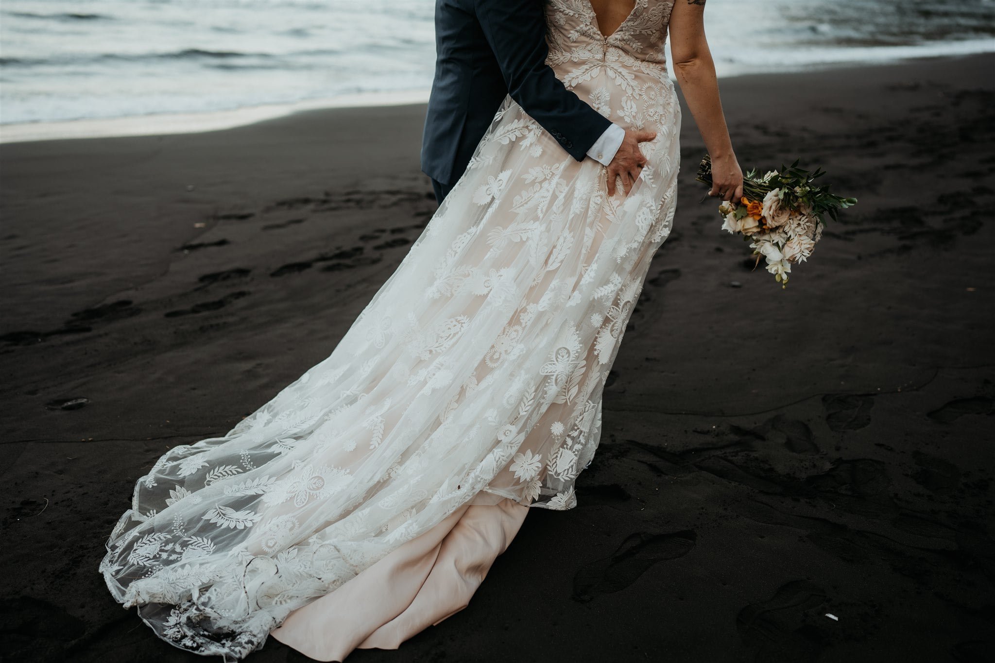 Bride and groom running across the beach at their Big Island elopement