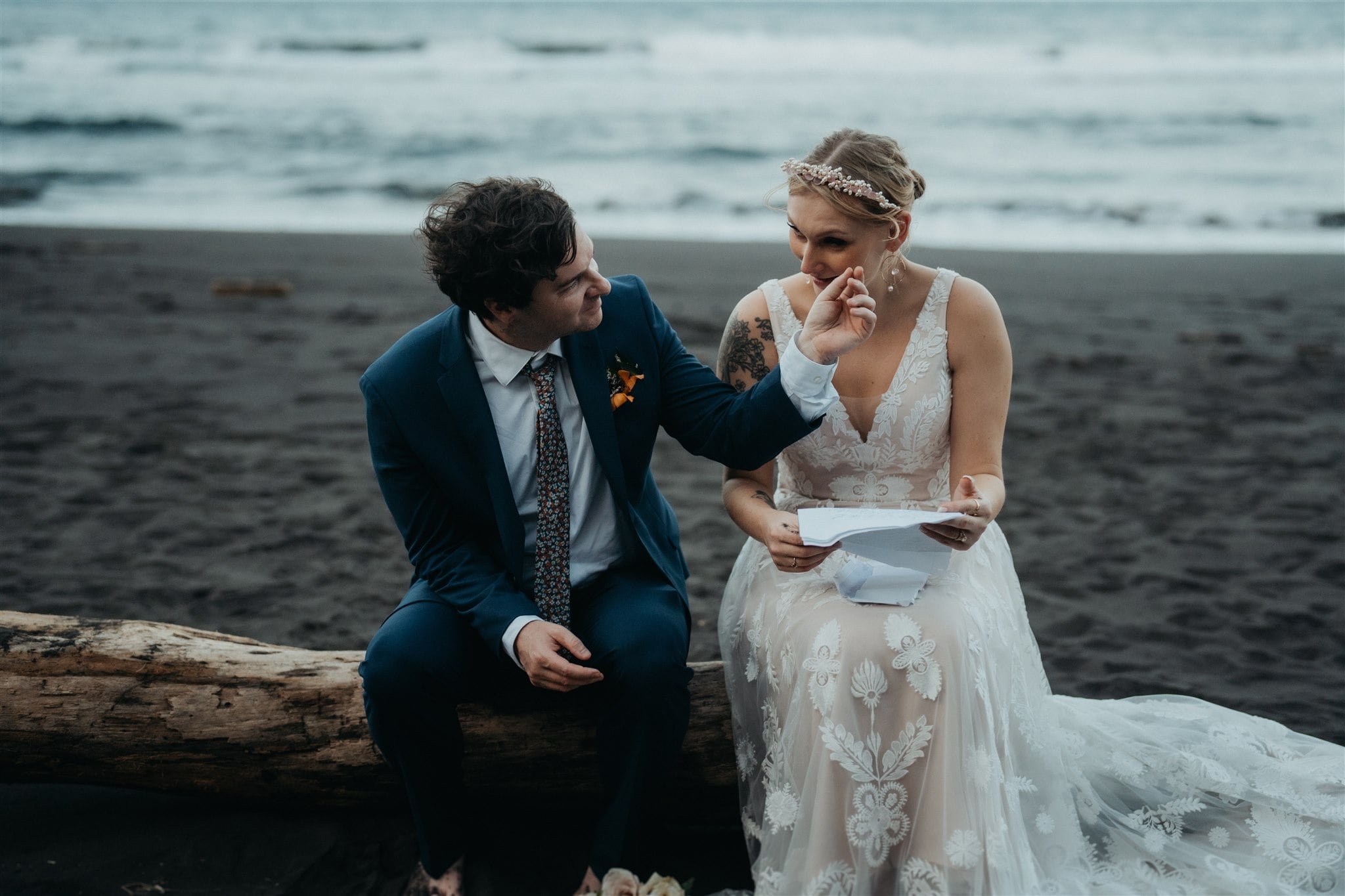 Bride and groom read letters on the beach at their Big Island elopement