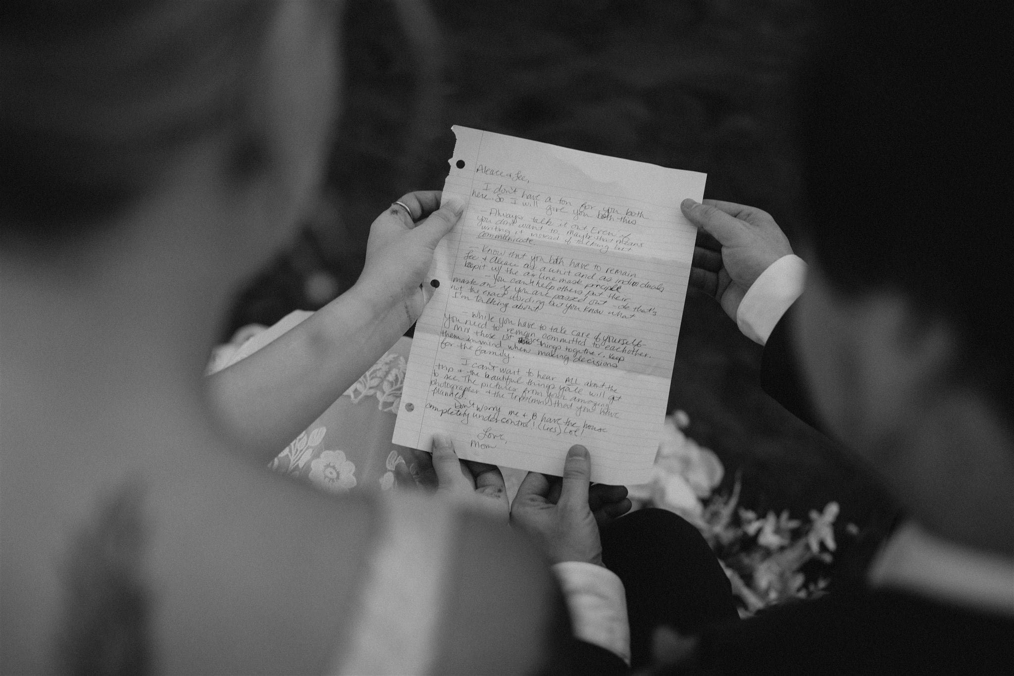 Bride and groom read letters on the beach at their Big Island elopement