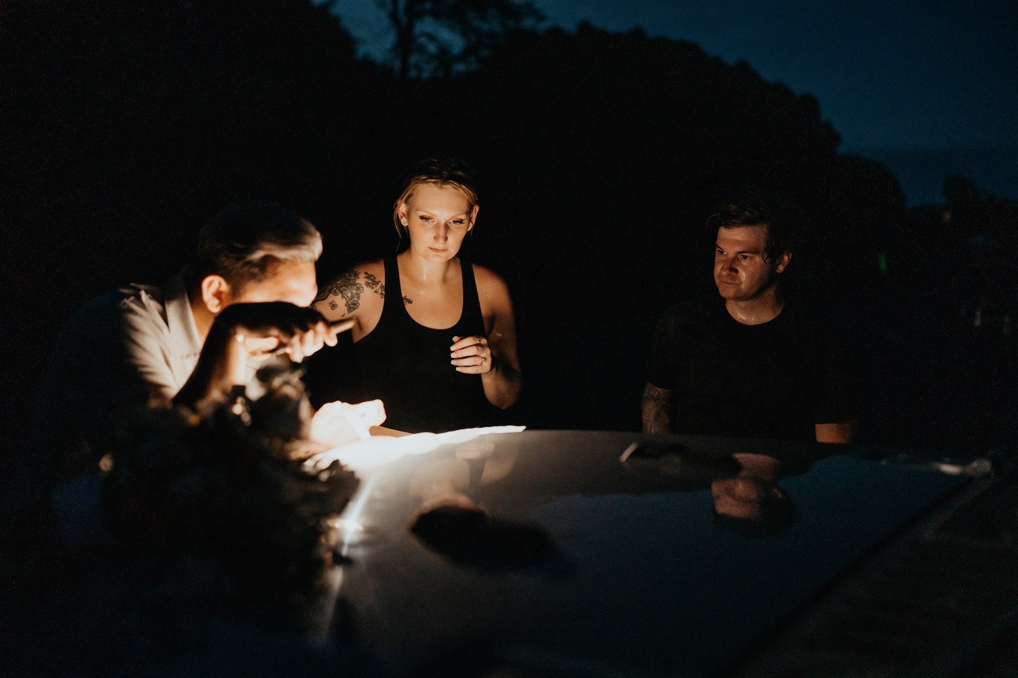 Bride and groom signing marriage certificate by headlamp light at their Big Island elopement