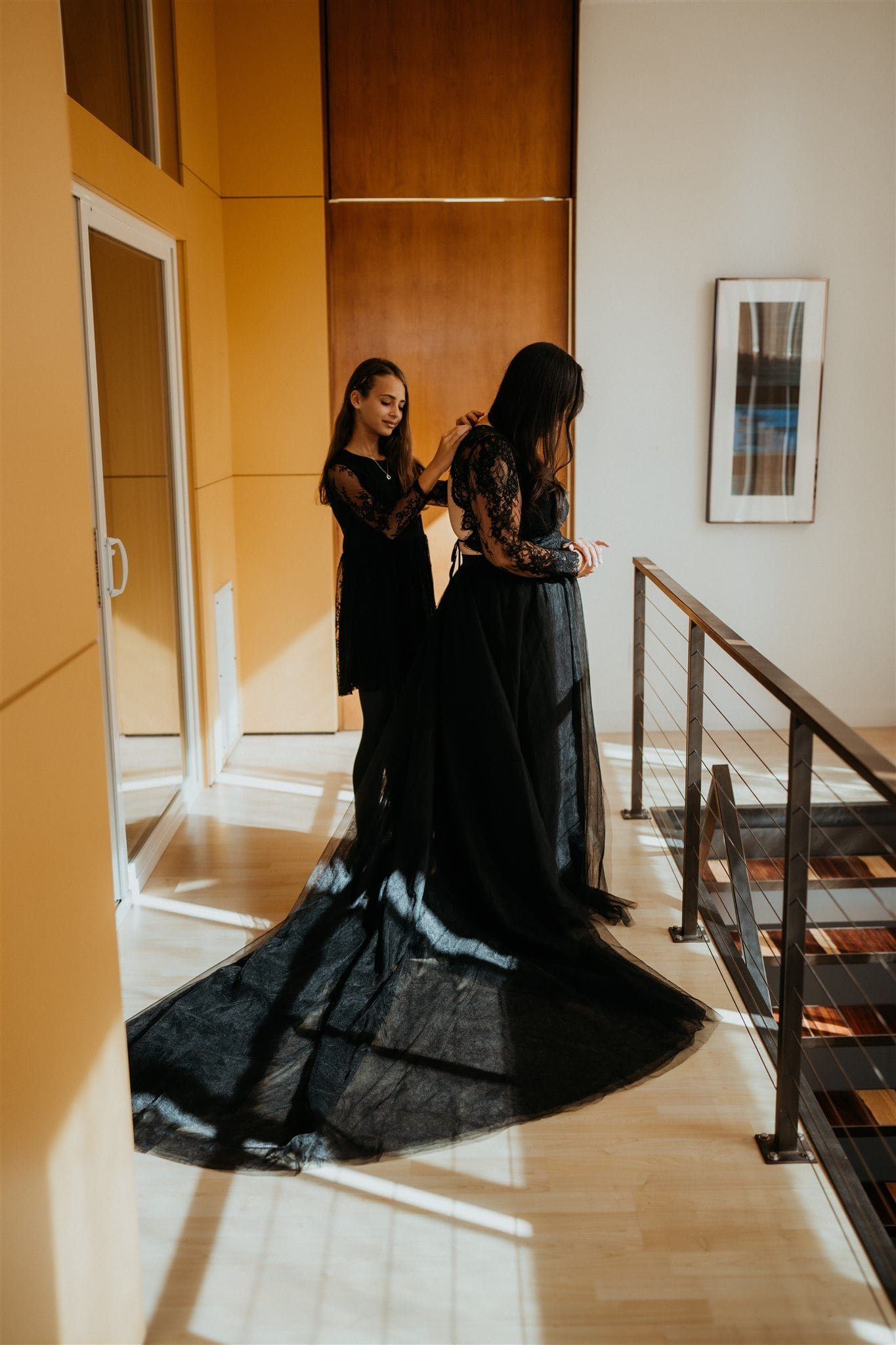 Daughter helping bride into her all black wedding dress while getting ready for Pacific Northwest elopement