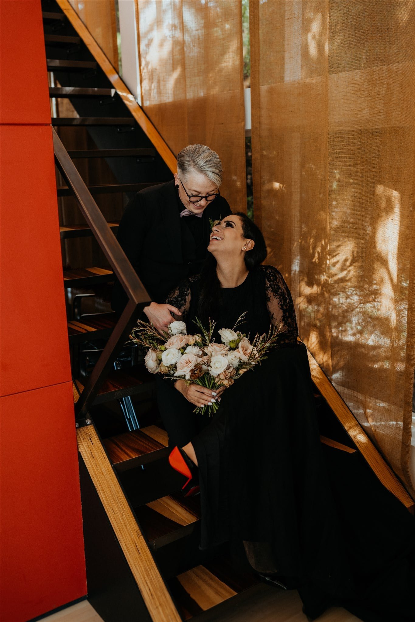 Brides sit on the steps of their Airbnb for elopement portraits before their Oregon Coast elopement ceremony