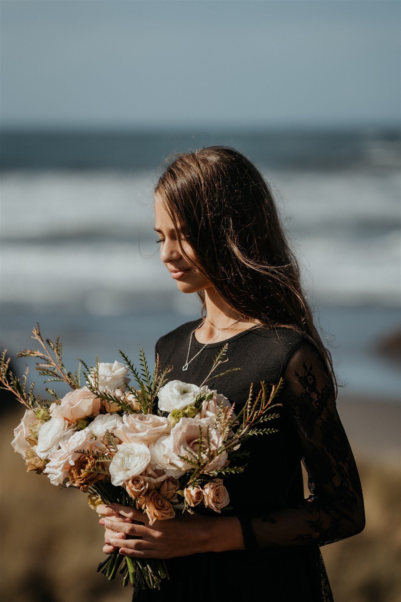 Daughter holds bouquet of neutral flowers during pacific northwest elopement ceremony