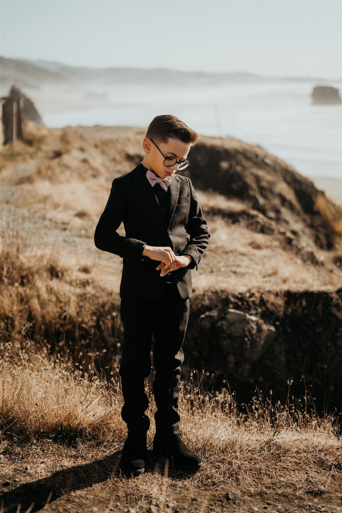 Son of the bride standing on the Oregon Coast during mother's pacific northwest elopement ceremony