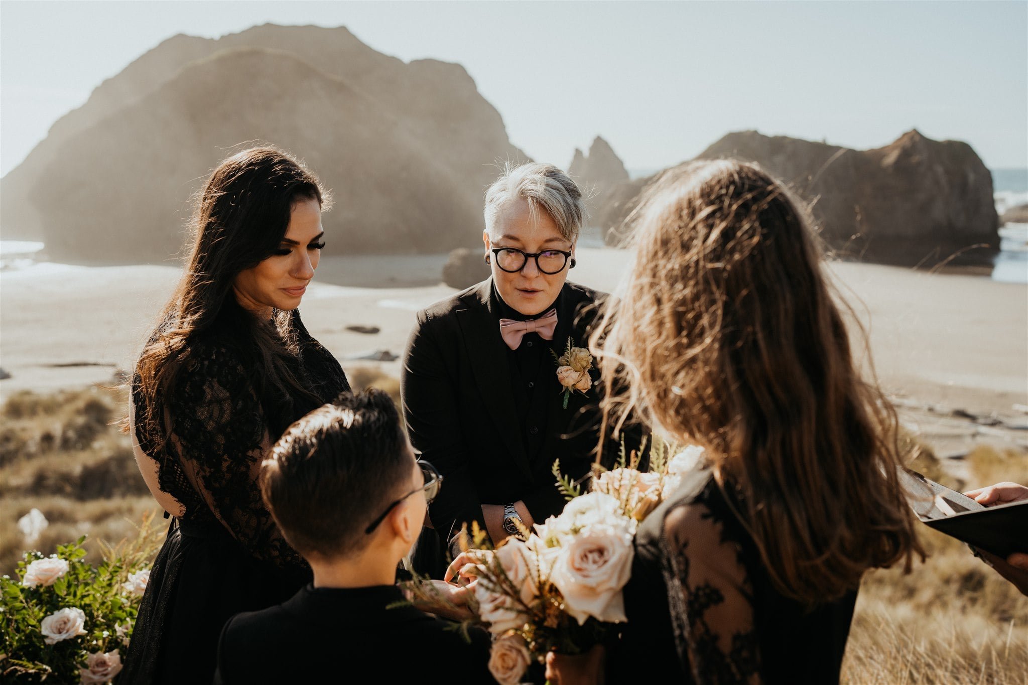 Brides and children stand in a circle during elopement ceremony on the Oregon Coast